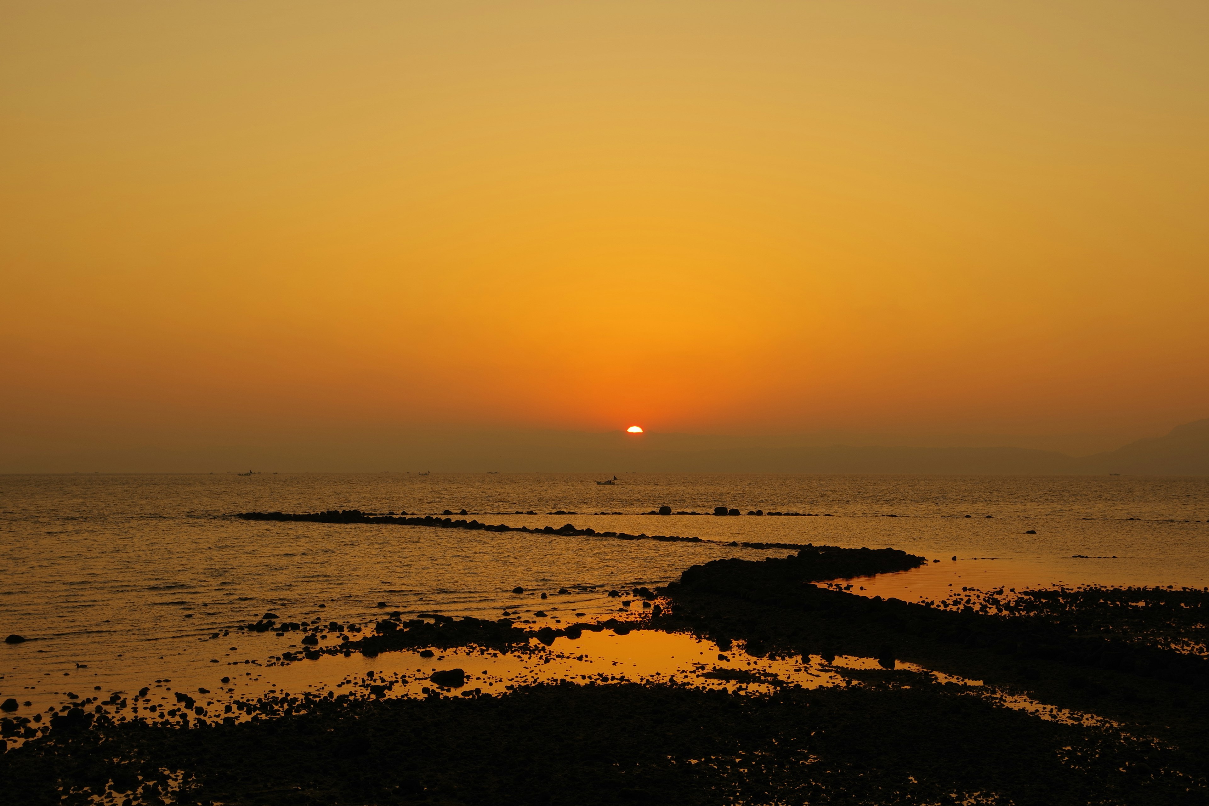 美しい夕日が海に沈む風景オレンジと黄色のグラデーションが空を彩る