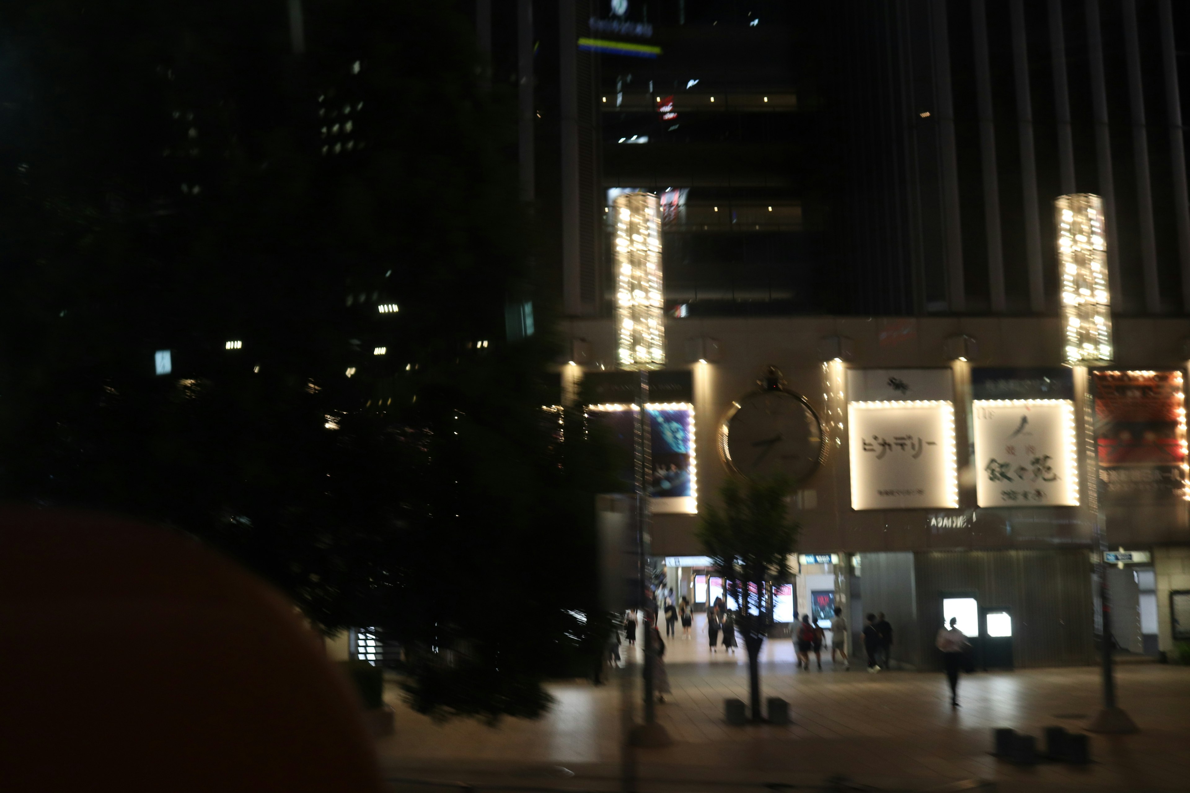 Paysage urbain nocturne avec des bâtiments lumineux et des gens