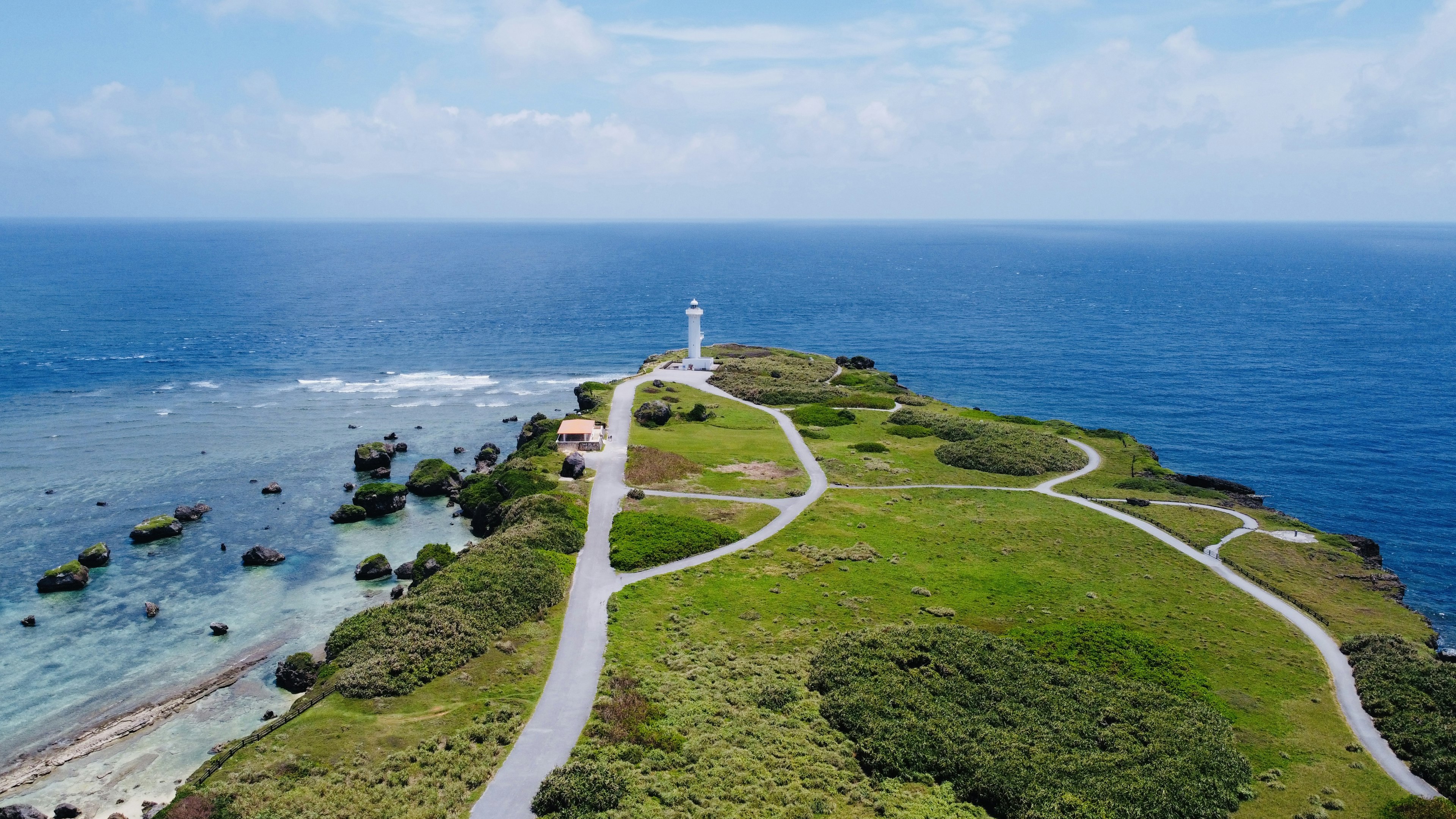 Vista panoramica di una penisola verde con un faro sull'oceano