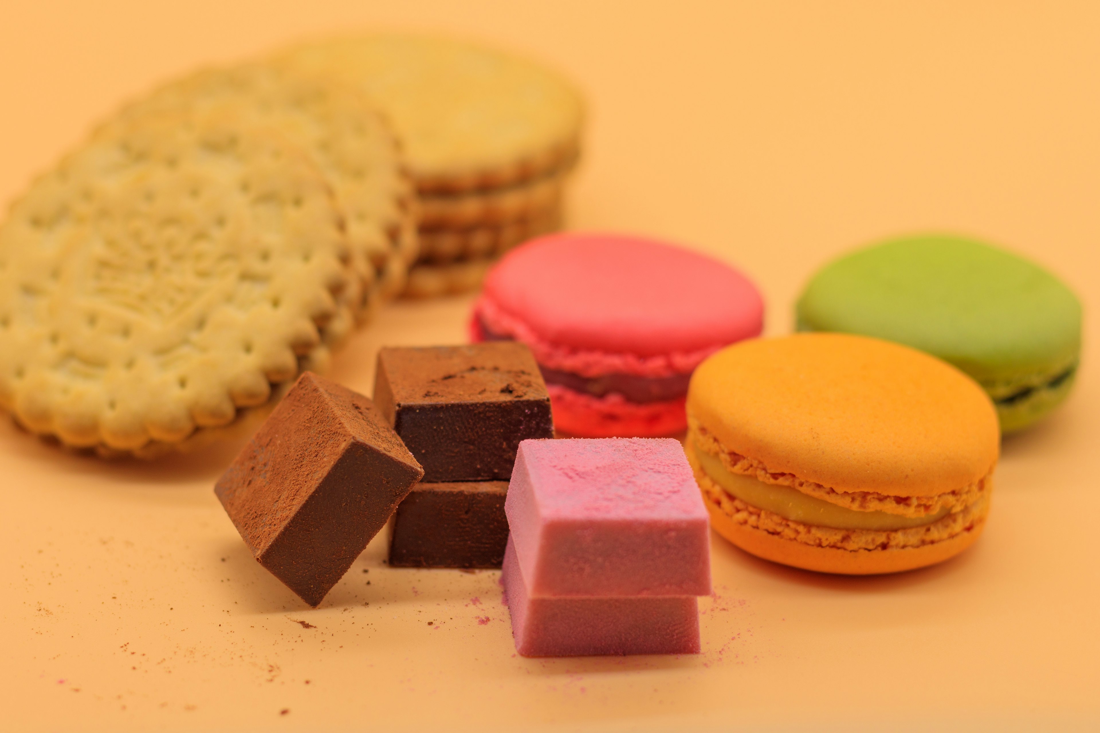 Macarons colorés et cubes de chocolat disposés dans une présentation sucrée