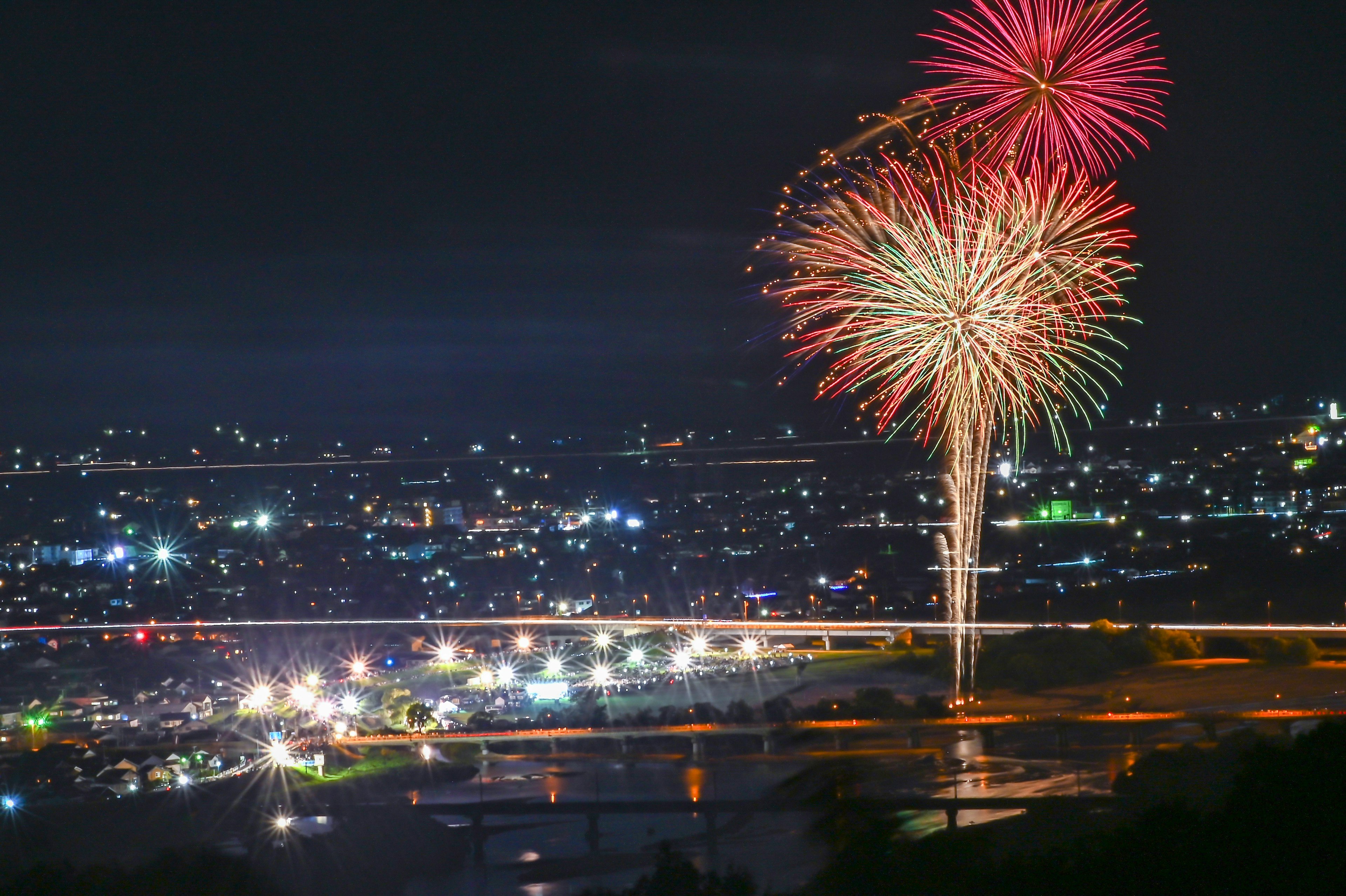 夜空に打ち上げられた花火と街の明かり