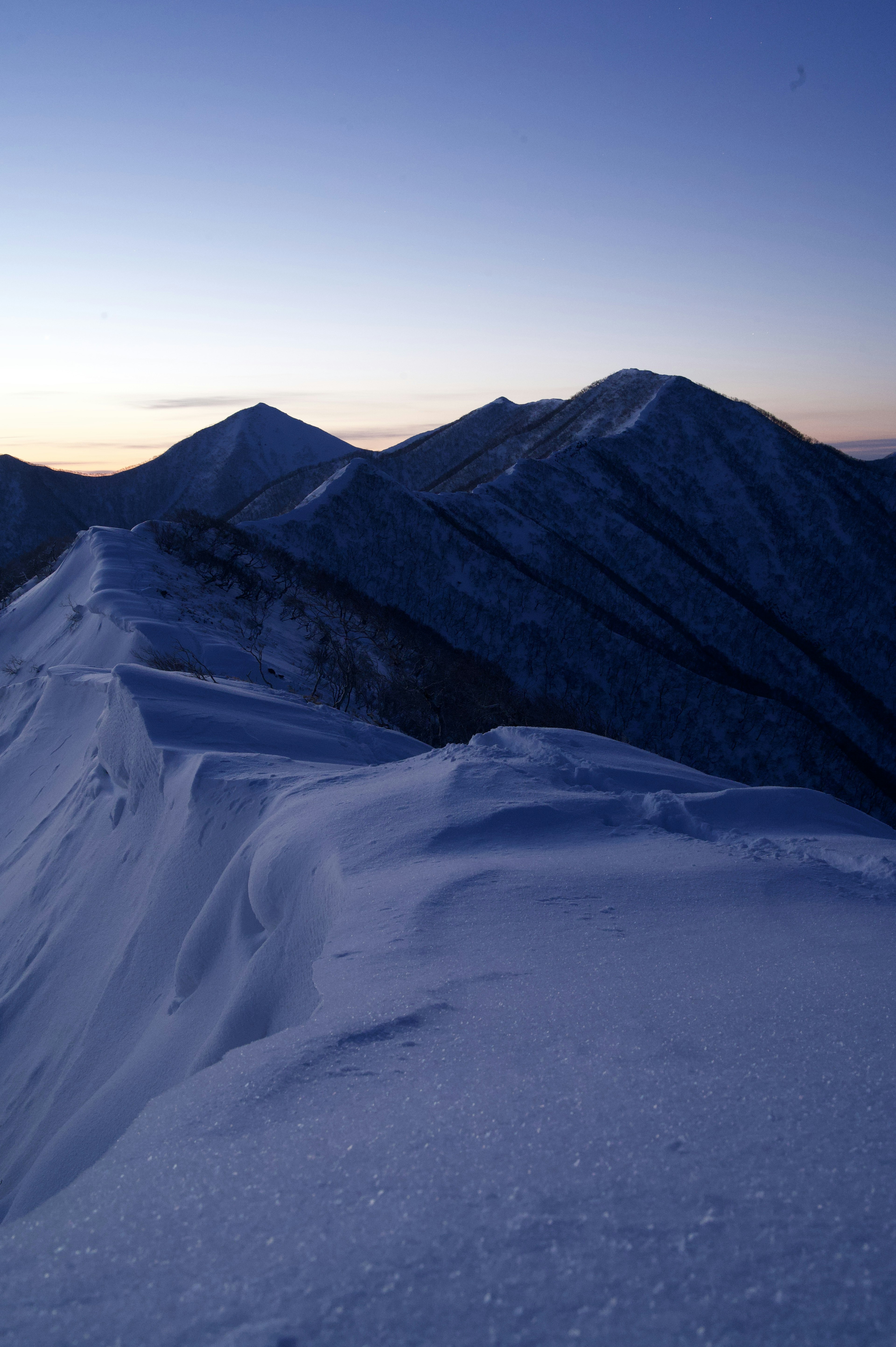 Montagnes enneigées sous un ciel crépusculaire