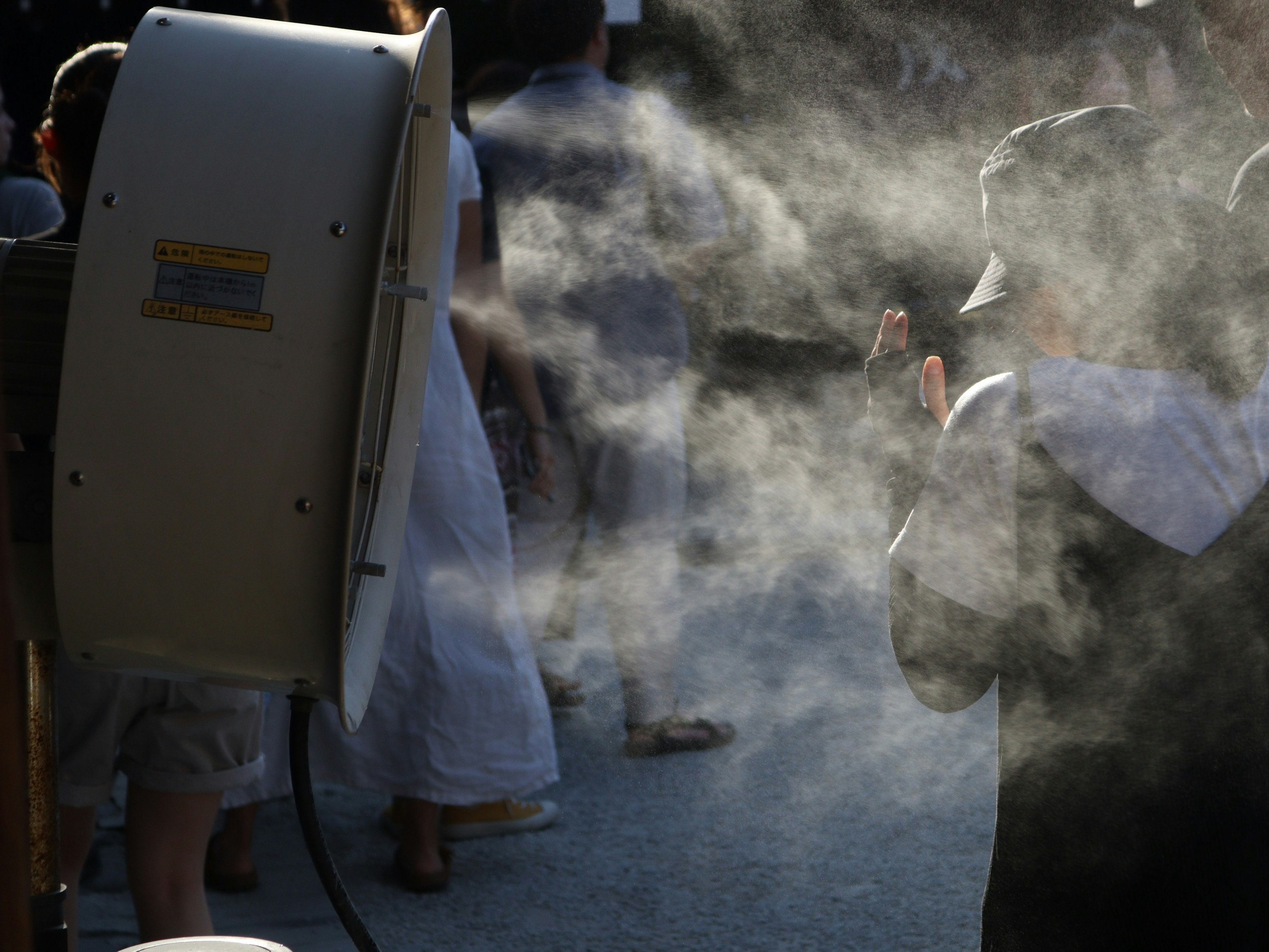 Scena con un grande ventilatore che emette nebbia dietro le persone