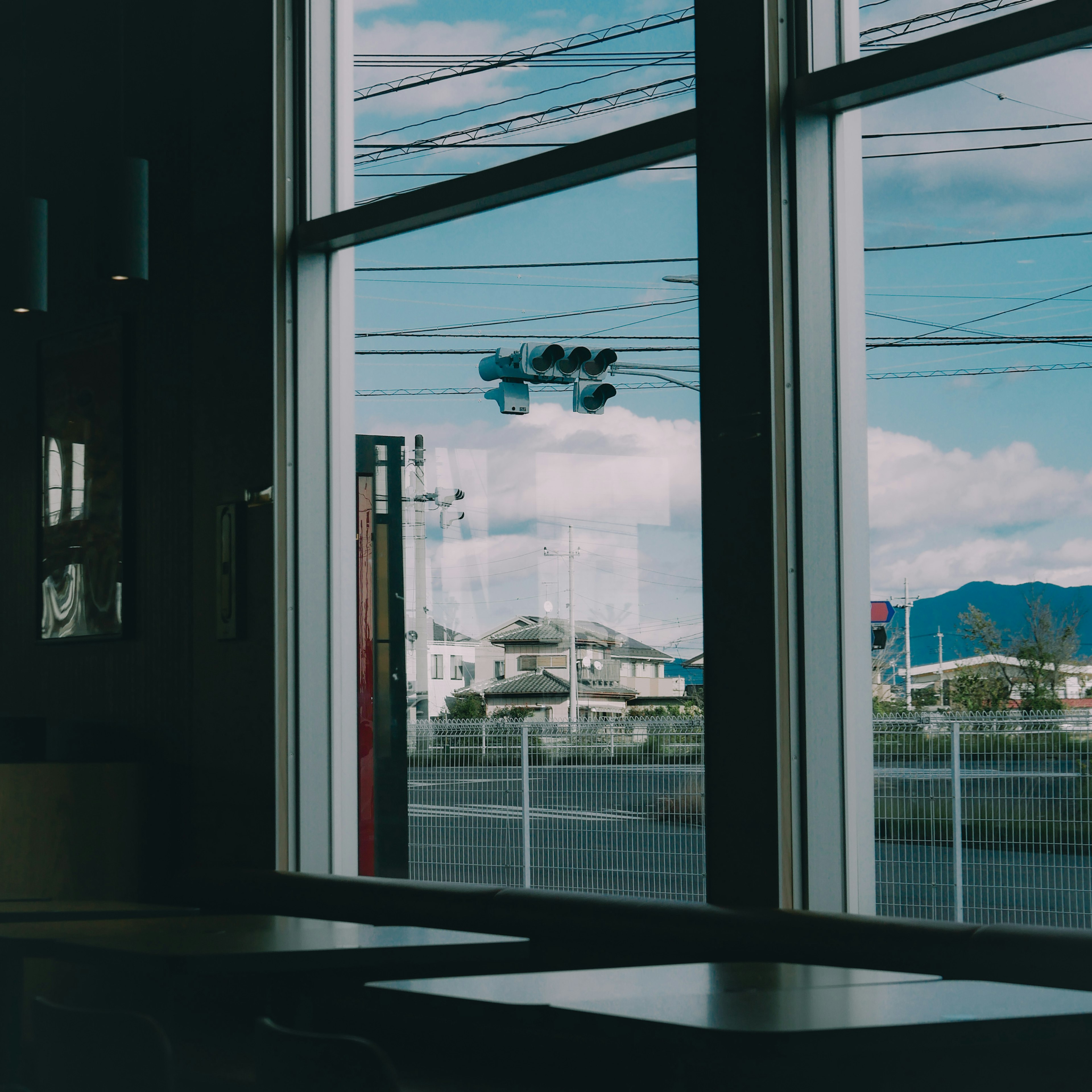 Innenansicht eines Cafés mit Blick auf den Himmel und Gebäude durch das Fenster