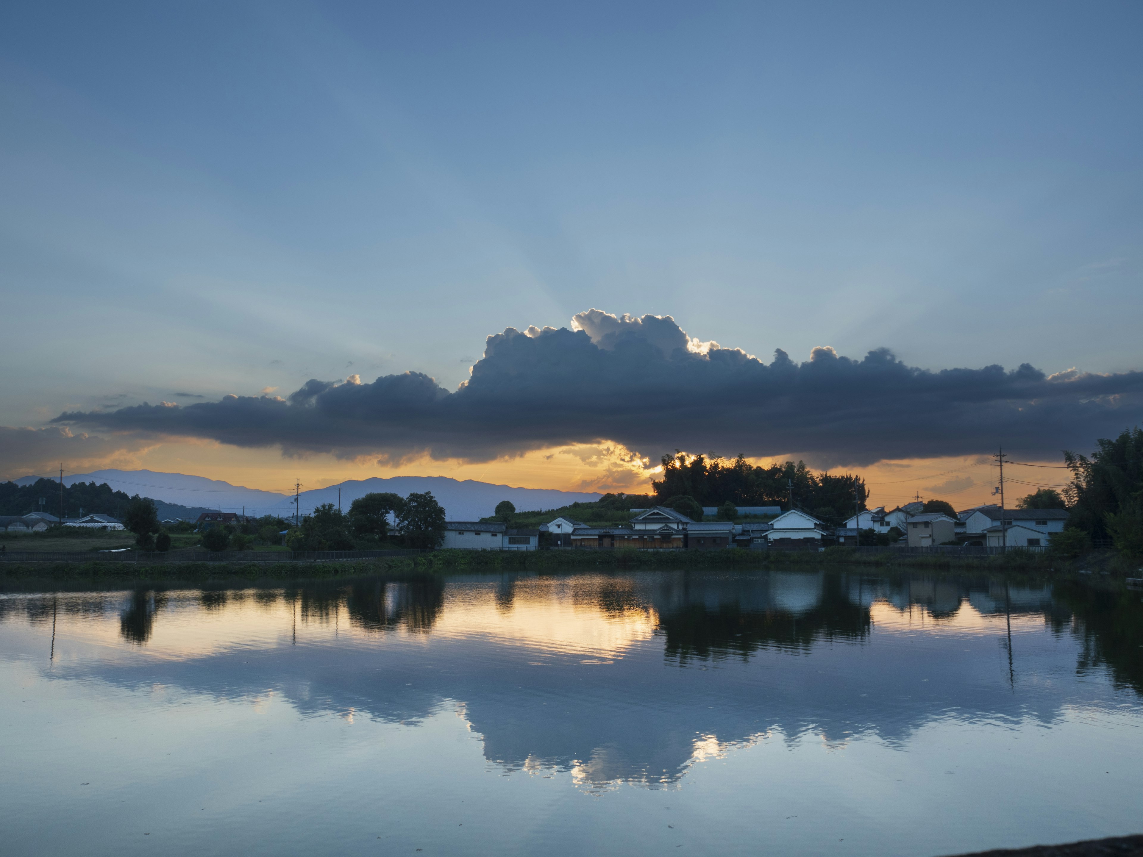 Vista panoramica di un tramonto su un lago con nuvole riflesse nell'acqua