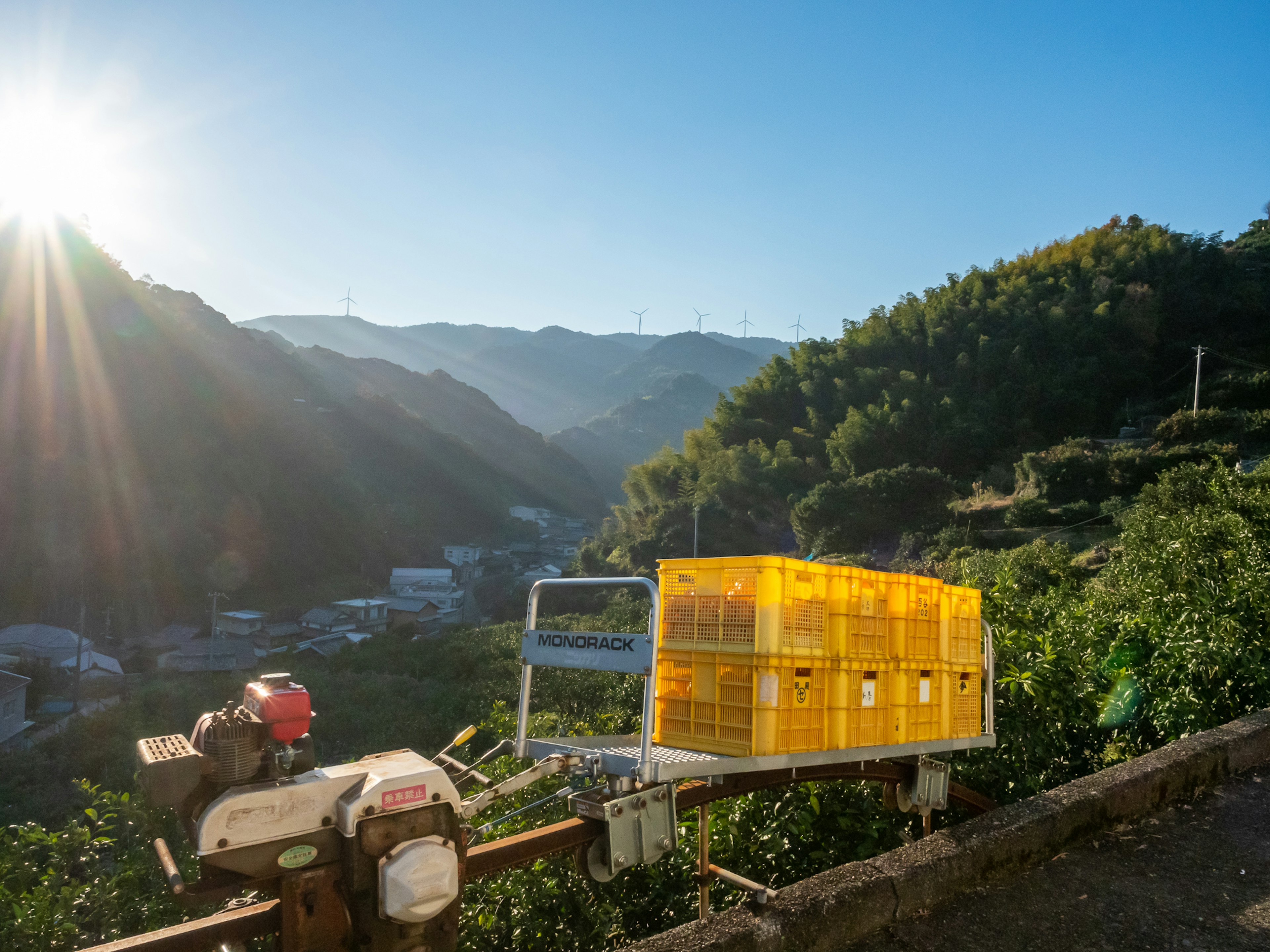 Paesaggio montano con una cassa di raccolta gialla in una scena agricola