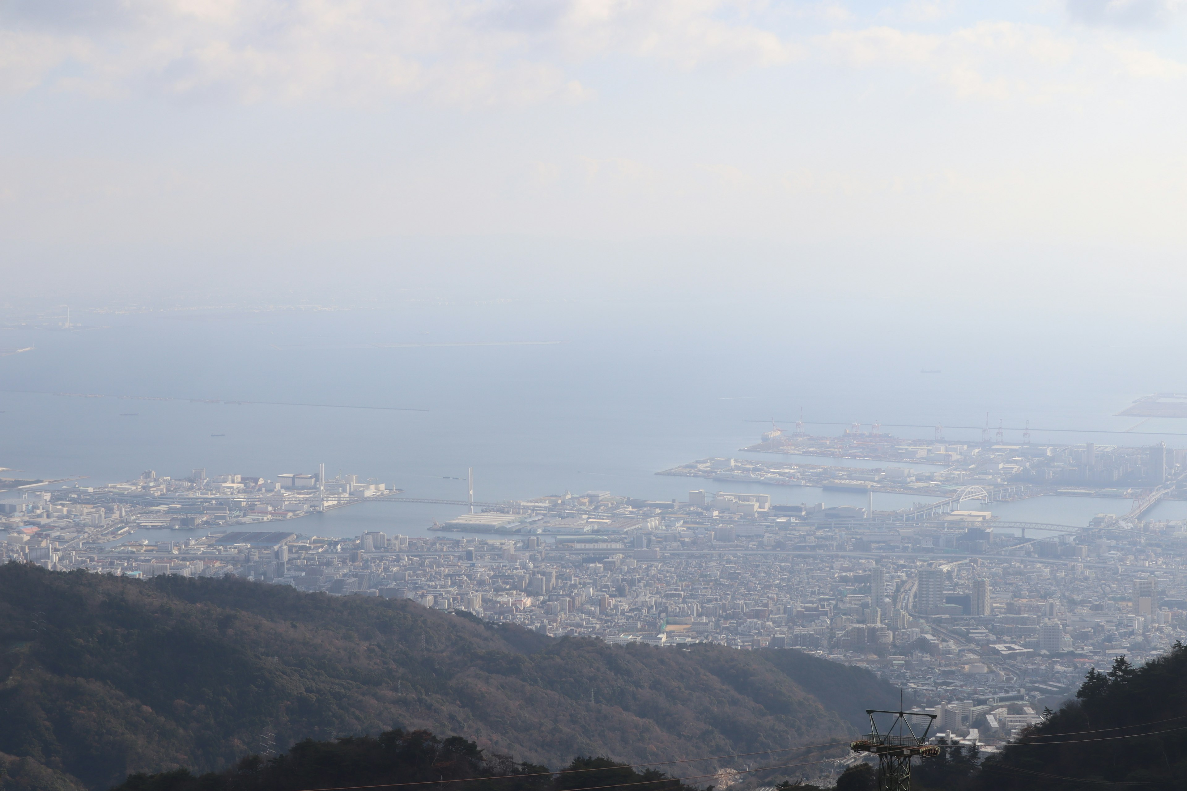 A panoramic view of a city and ocean from a mountain