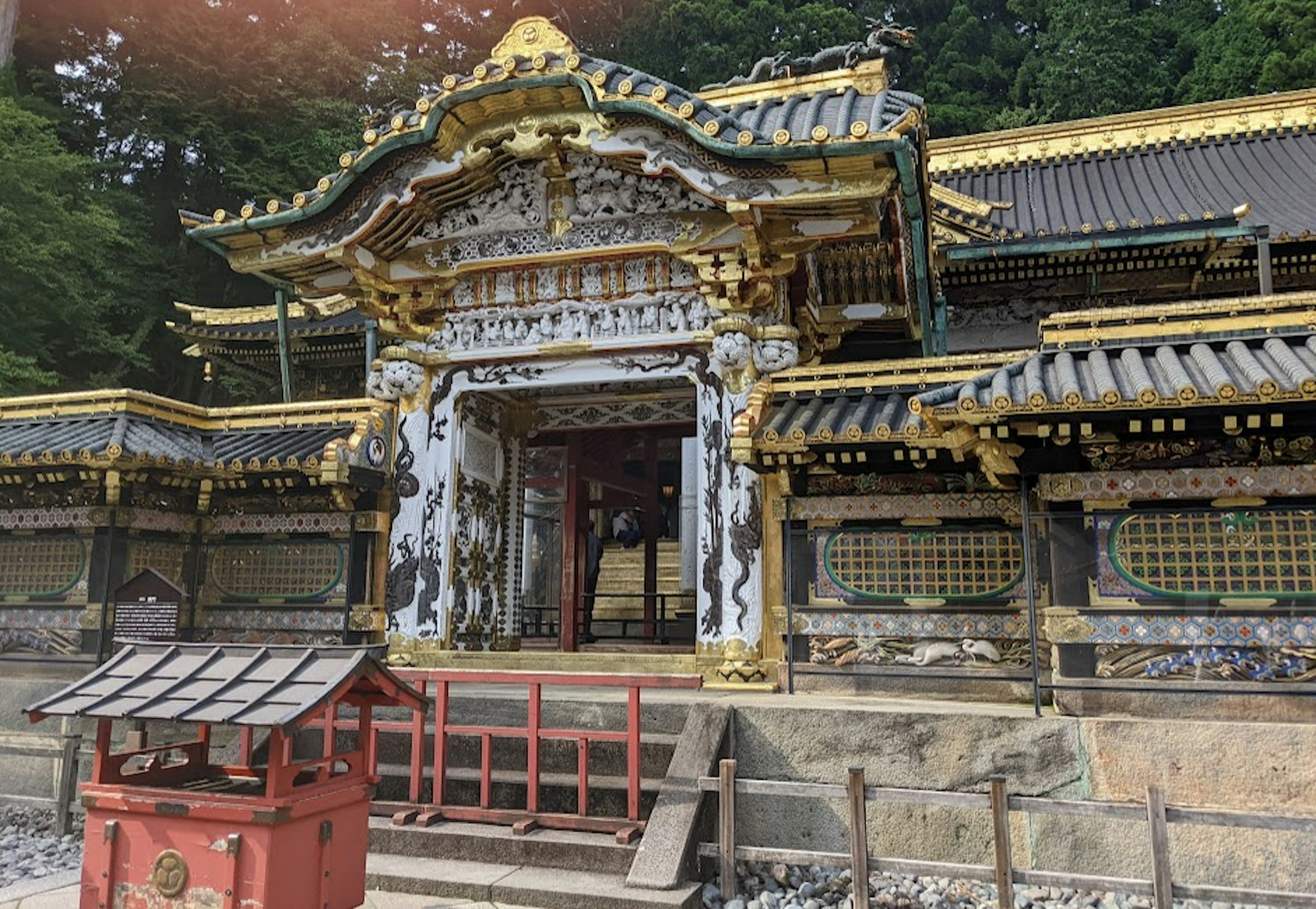 Structure décorée de manière élaborée du sanctuaire Toshogu de Nikko entourée de verdure luxuriante