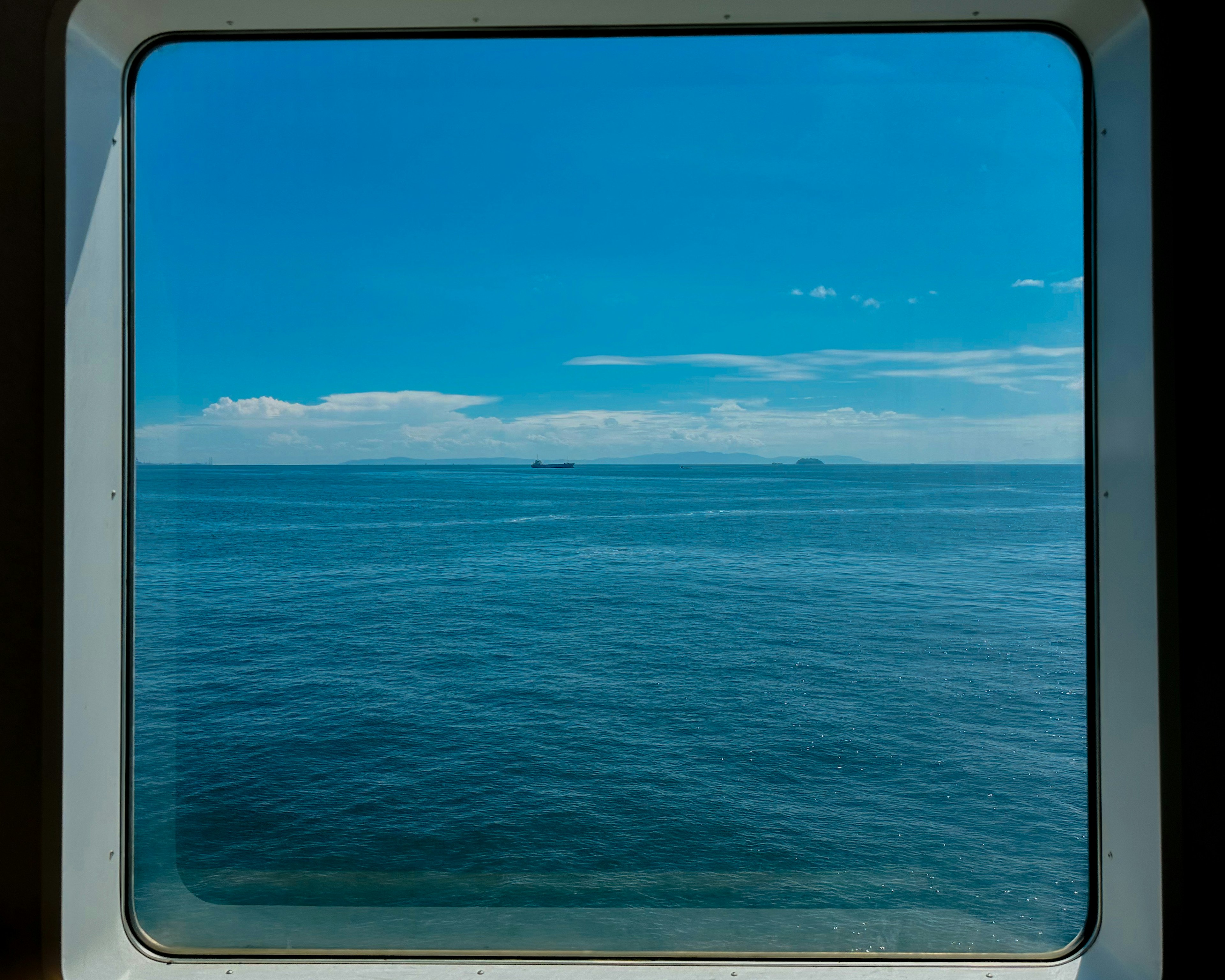 View of blue sea and sky through a window