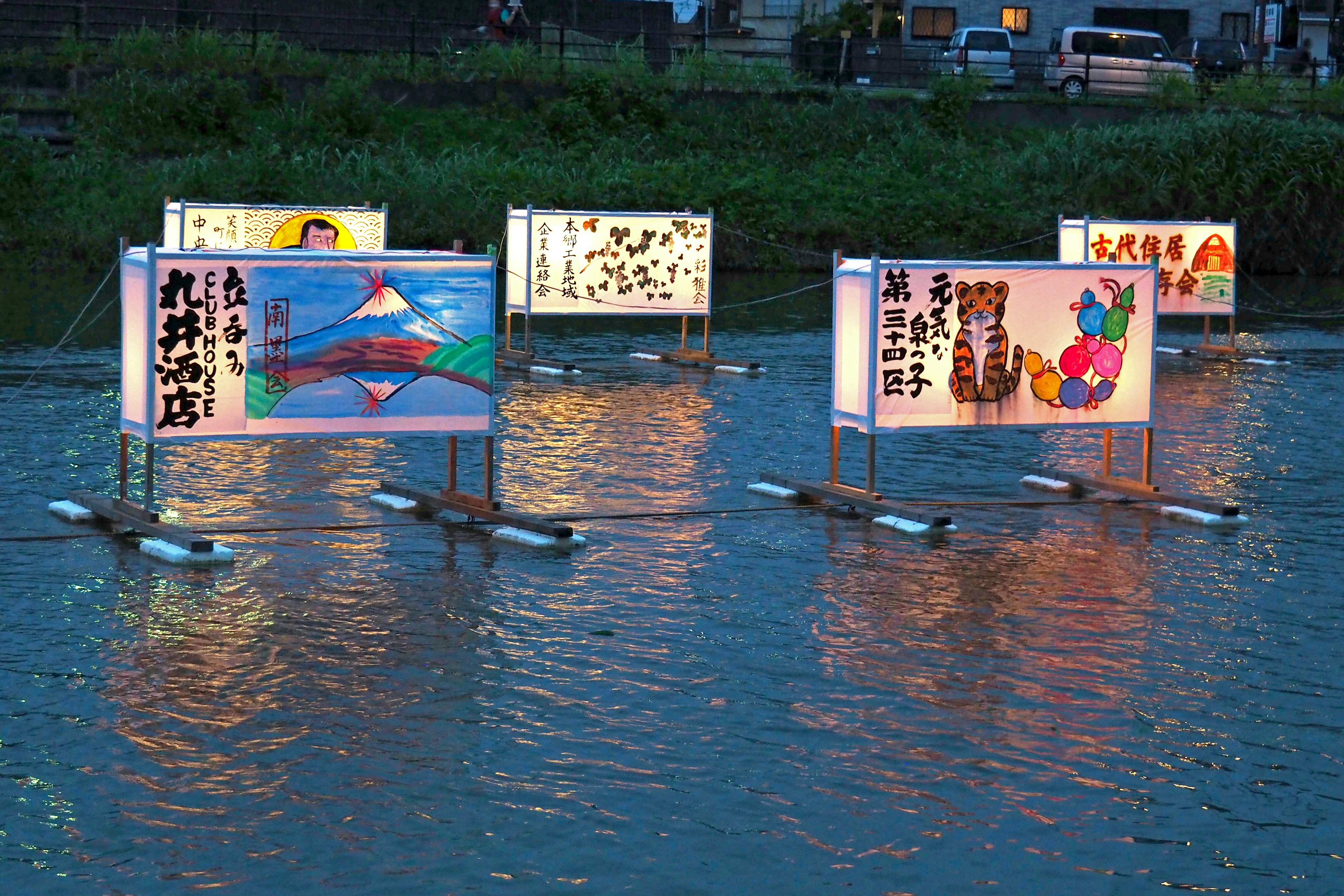 水面に浮かぶカラフルな看板が並ぶ夕暮れの風景