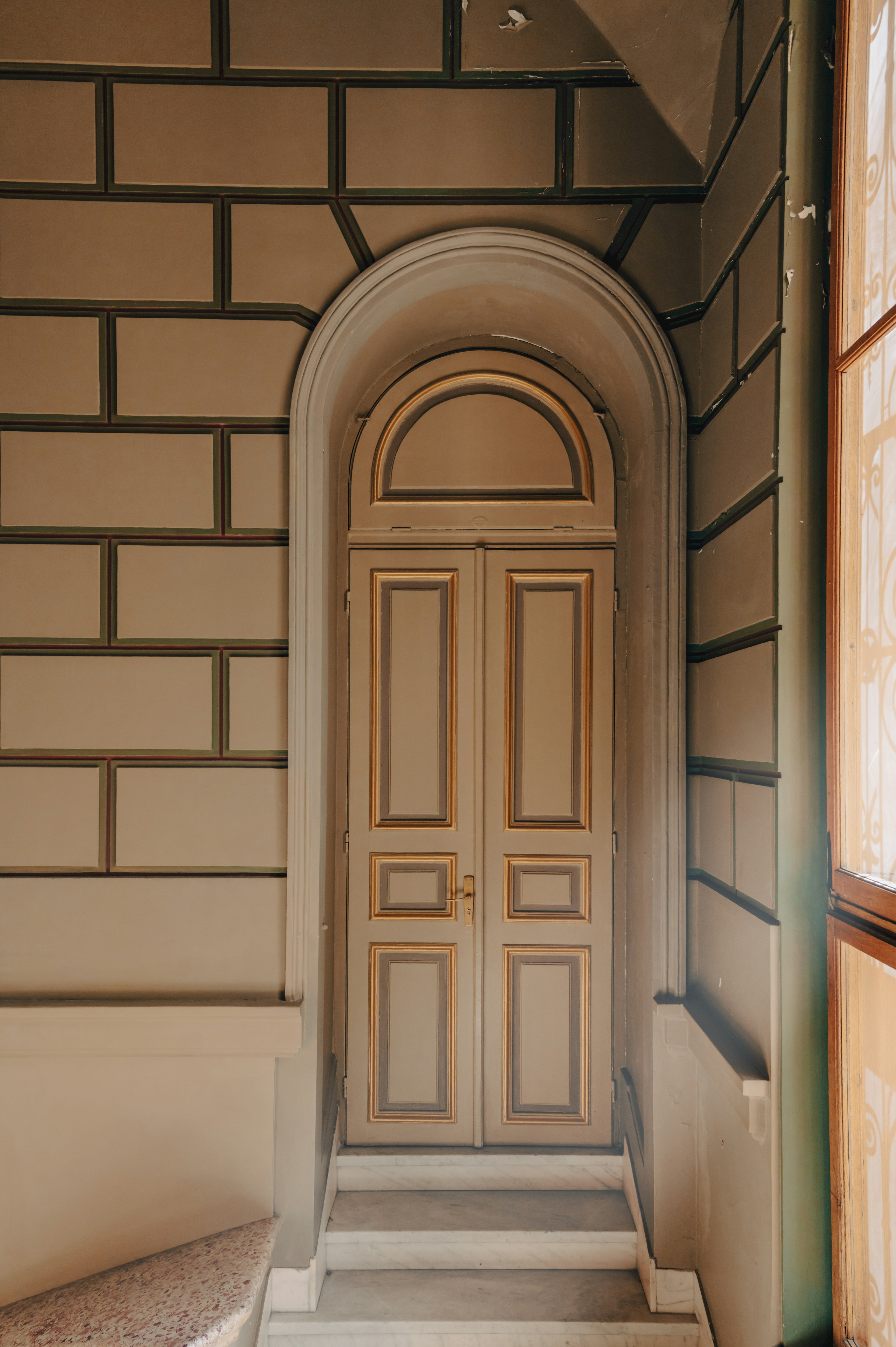 Vista interna con una porta ad arco chiaro e un design murale unico