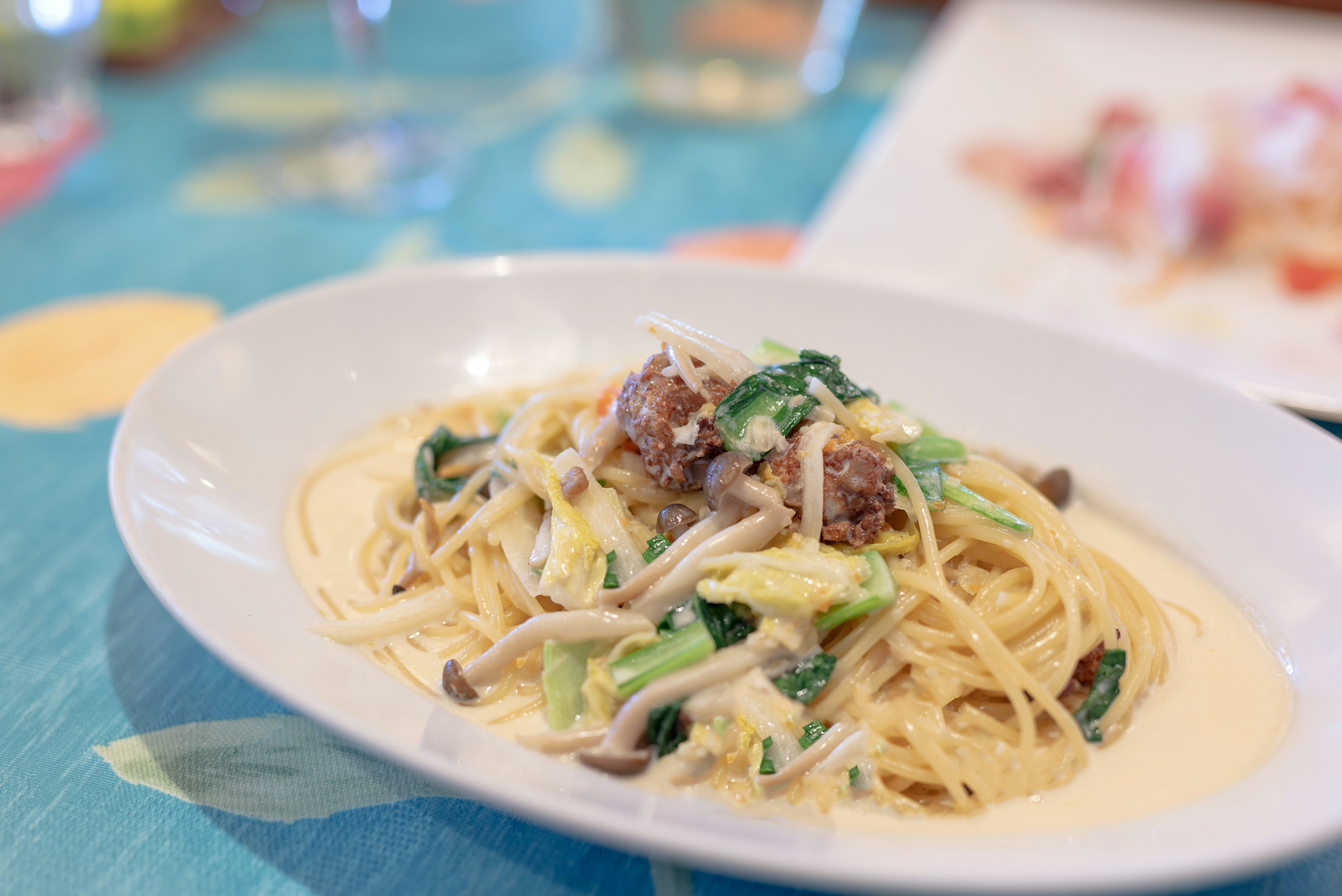 クリーミーなソースのパスタに野菜と肉のトッピング