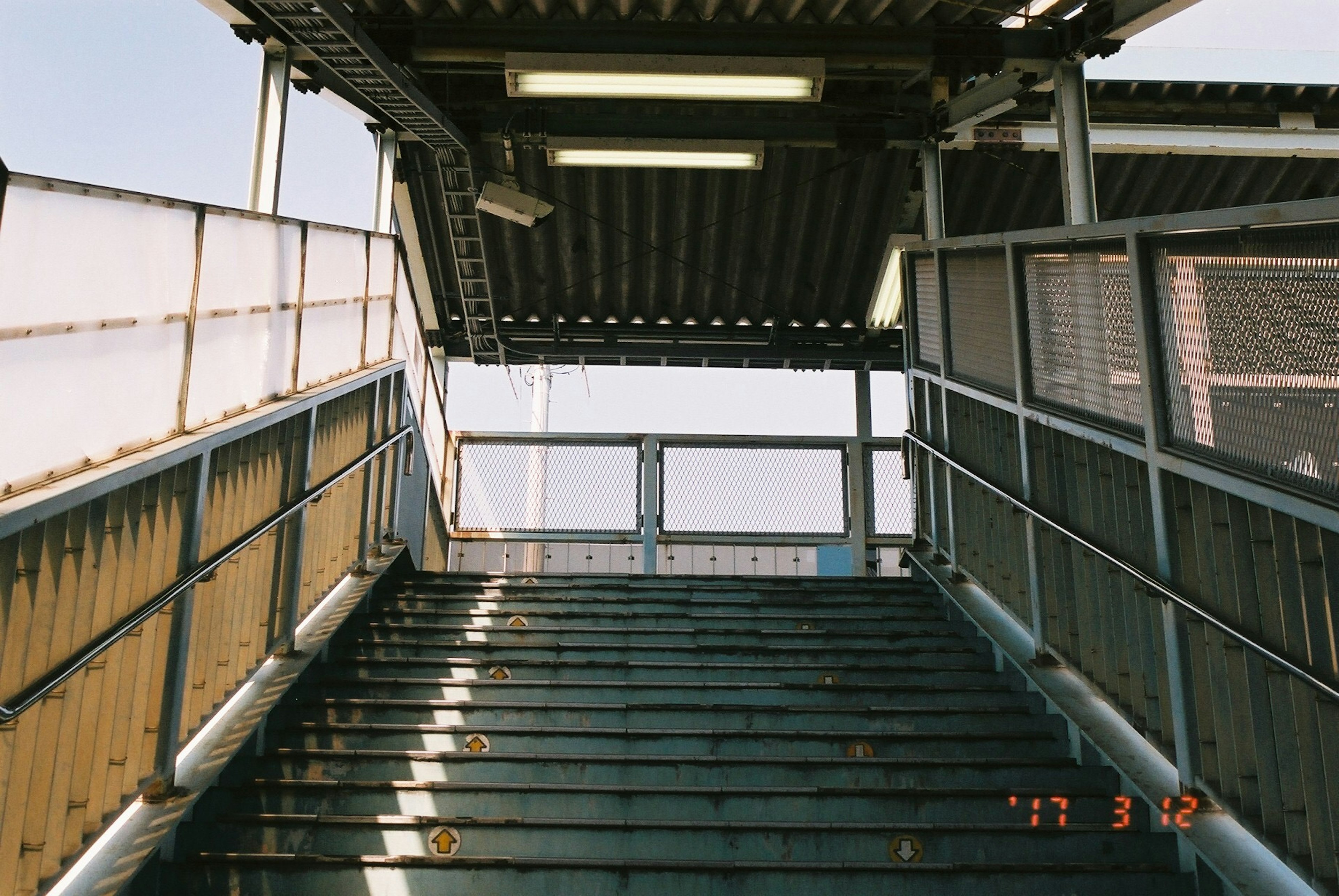 Vista de una entrada de estación con escaleras que llevan hacia arriba