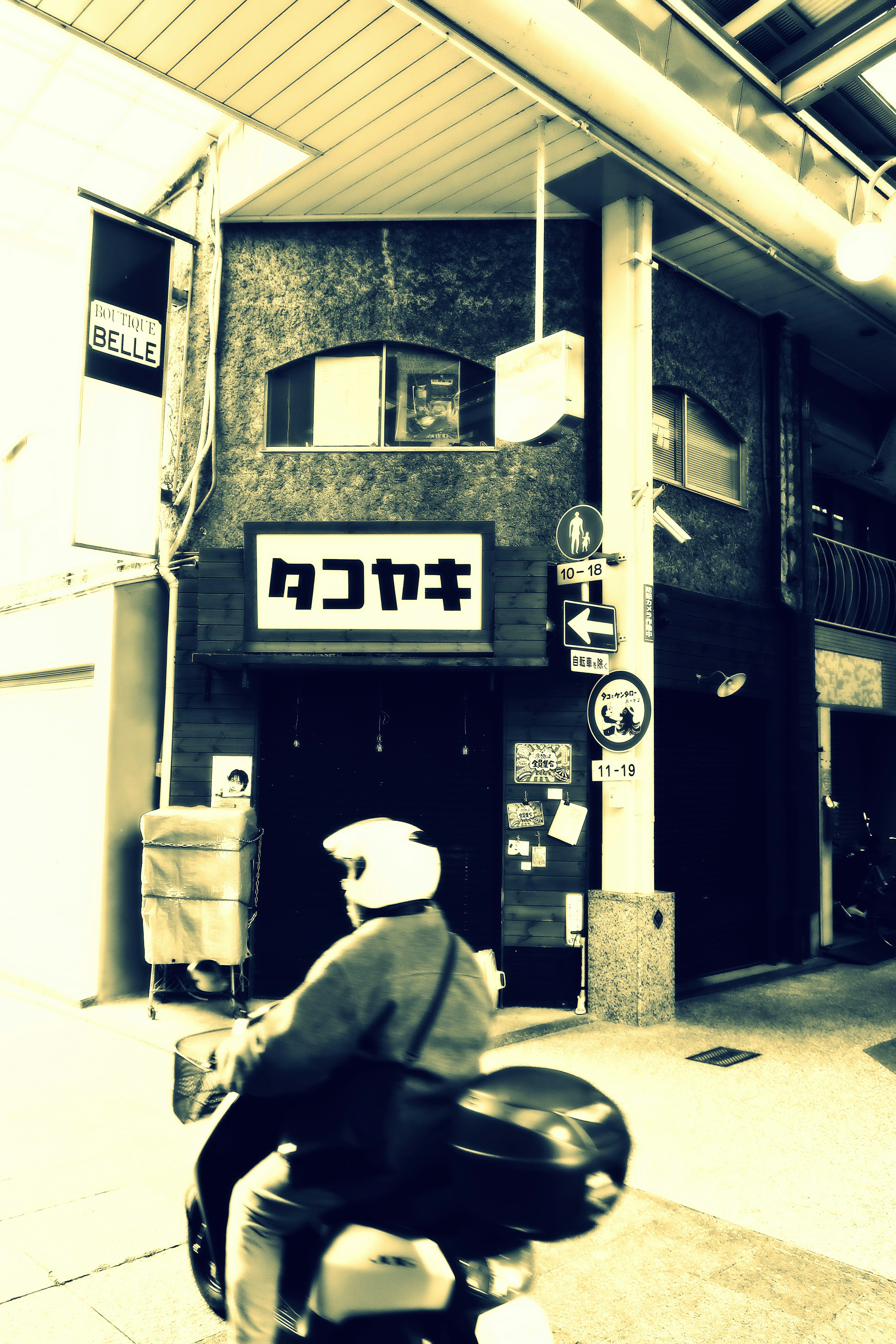 Takoyaki shop exterior with delivery rider on a motorcycle