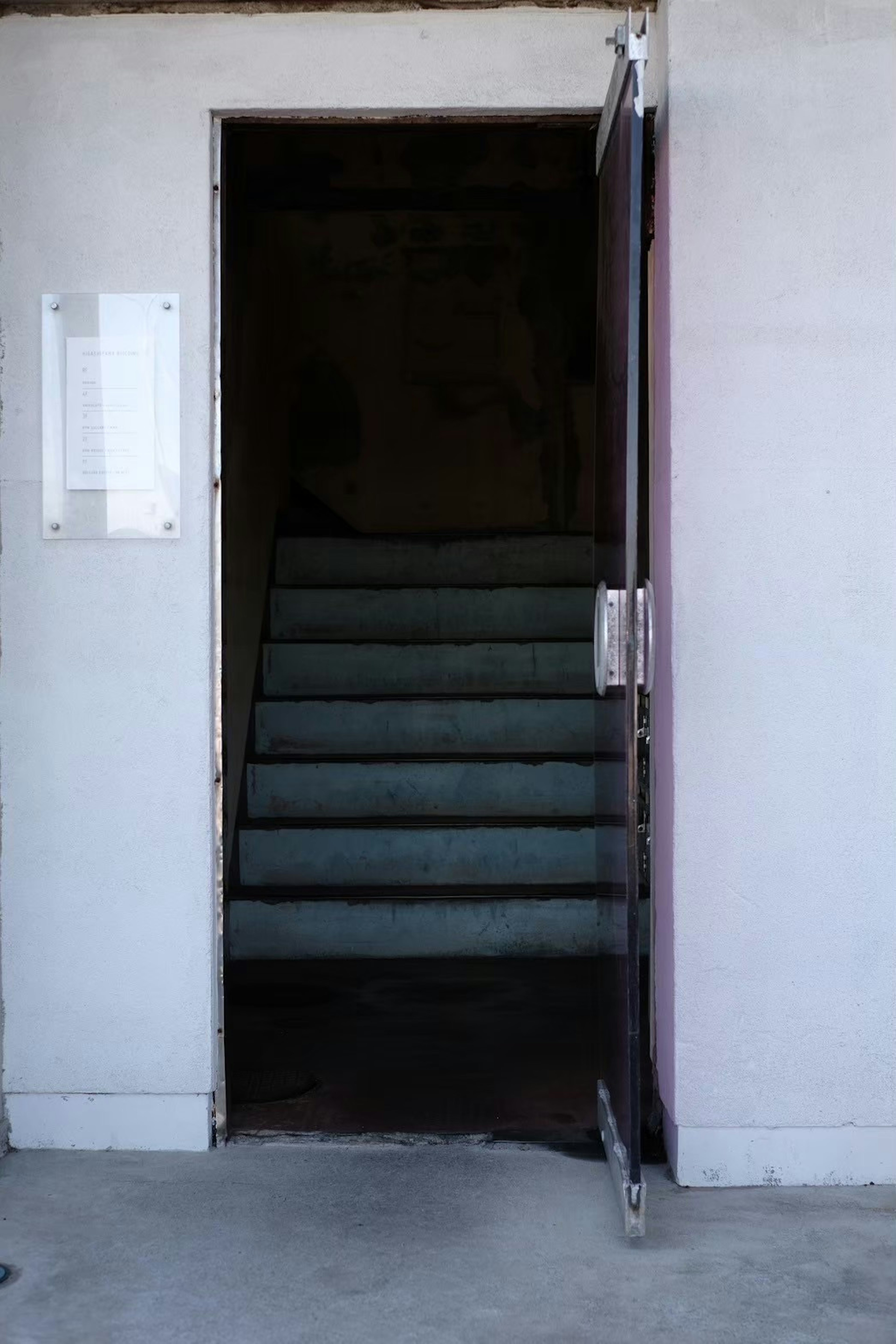 Immagine di una porta aperta che conduce a una scala in uno spazio buio