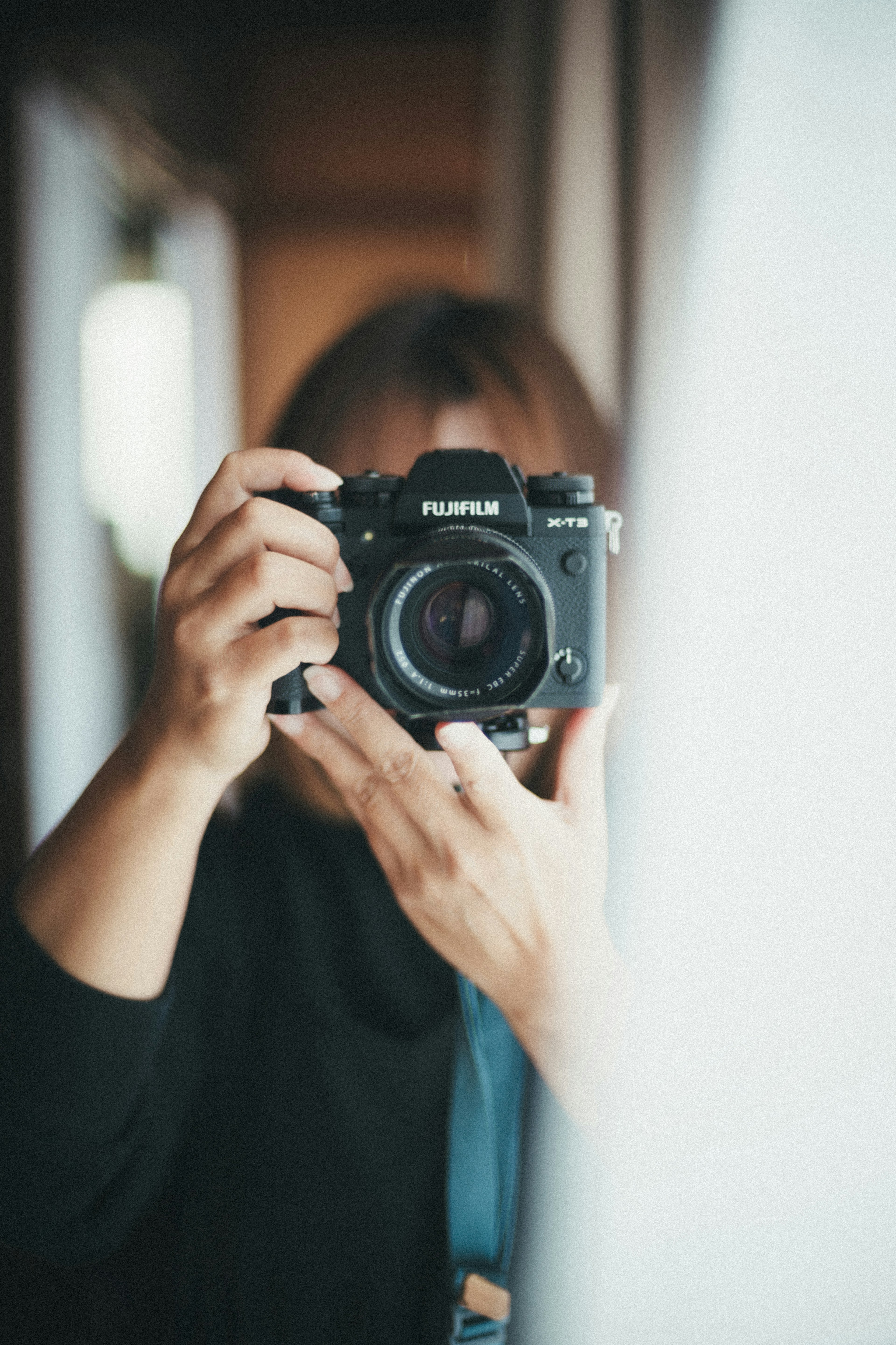 Portrait of a woman holding a camera captured in natural light