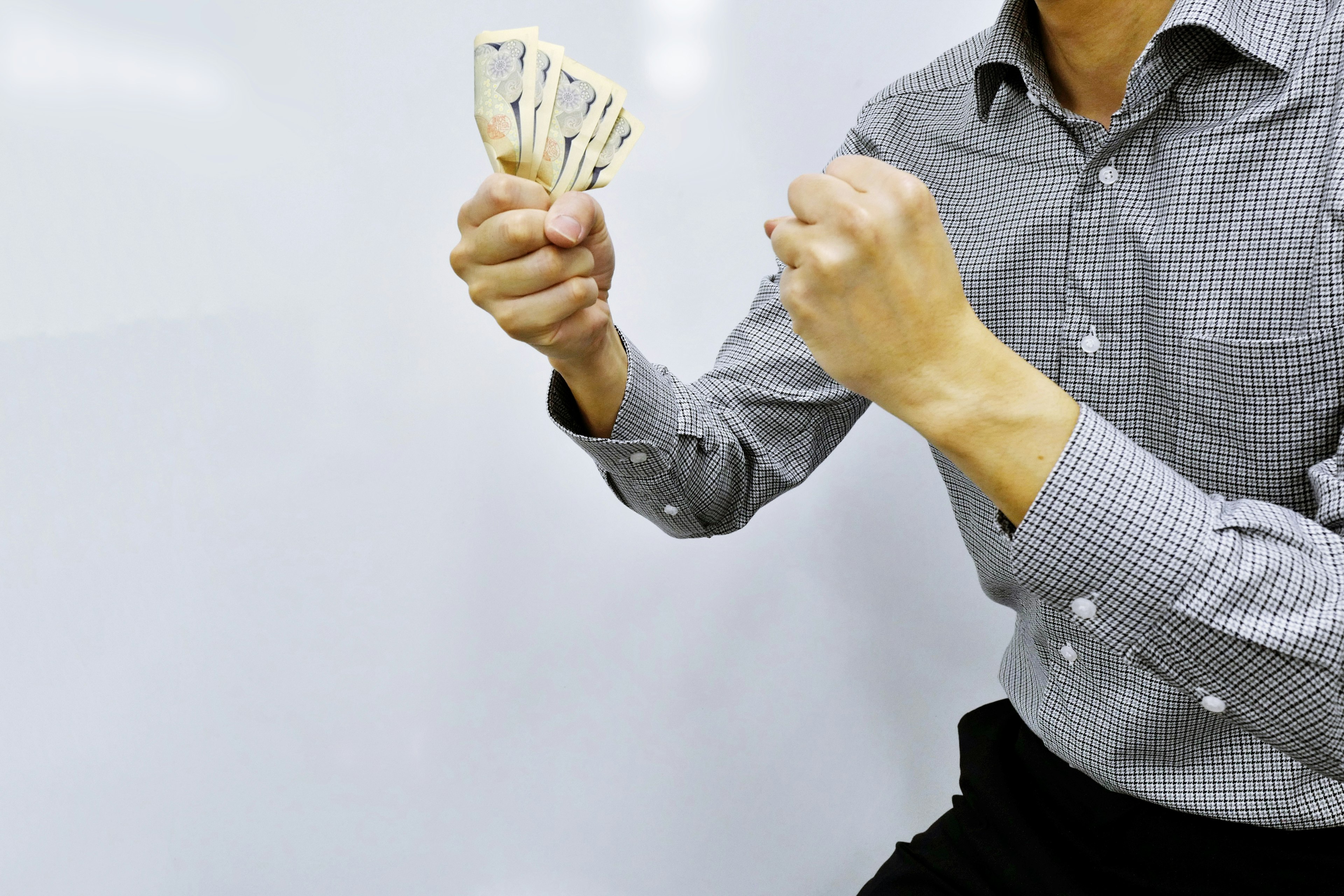 A man holding cash in one hand with a tense posture