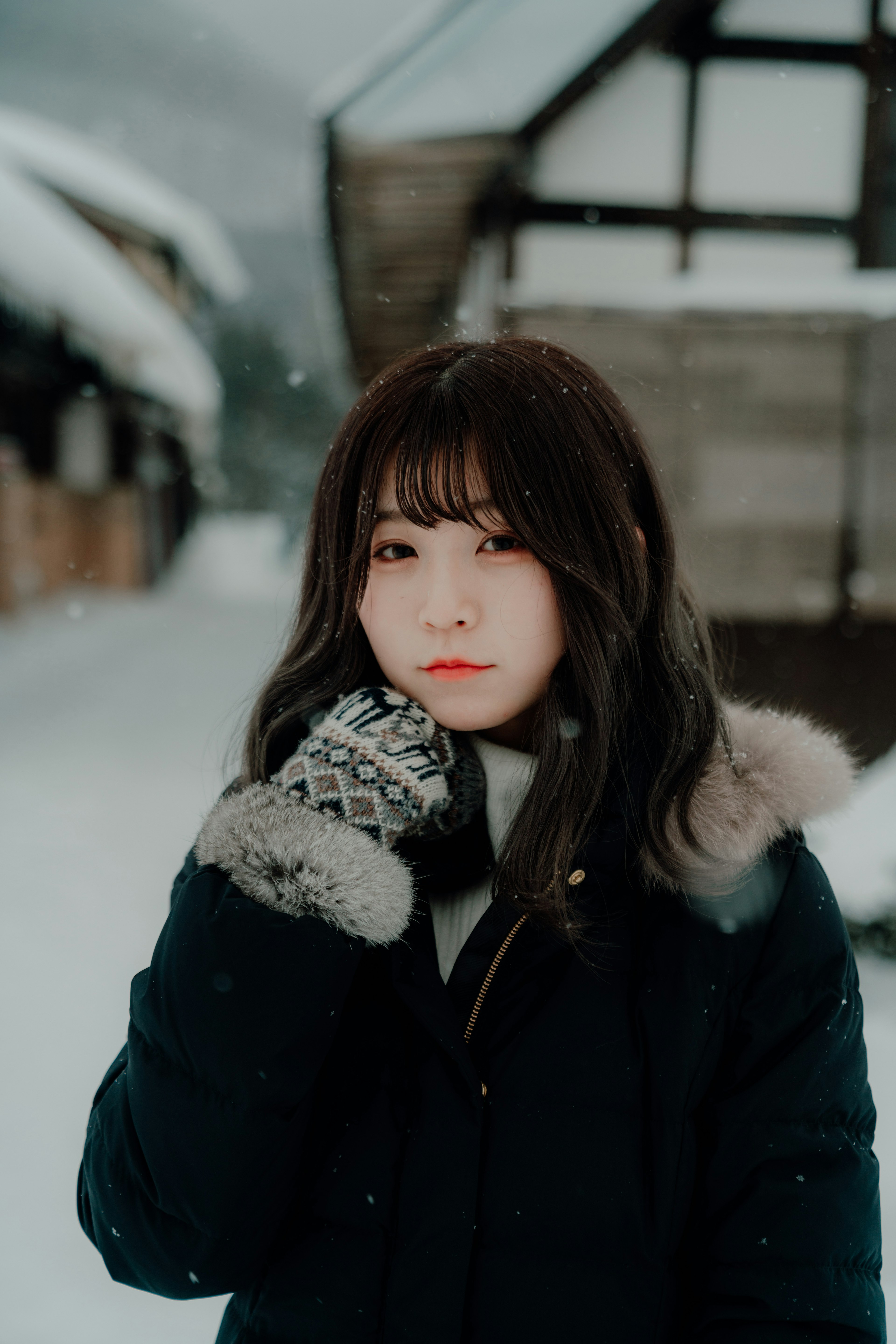 Retrato de una mujer en la nieve de invierno sosteniendo su rostro