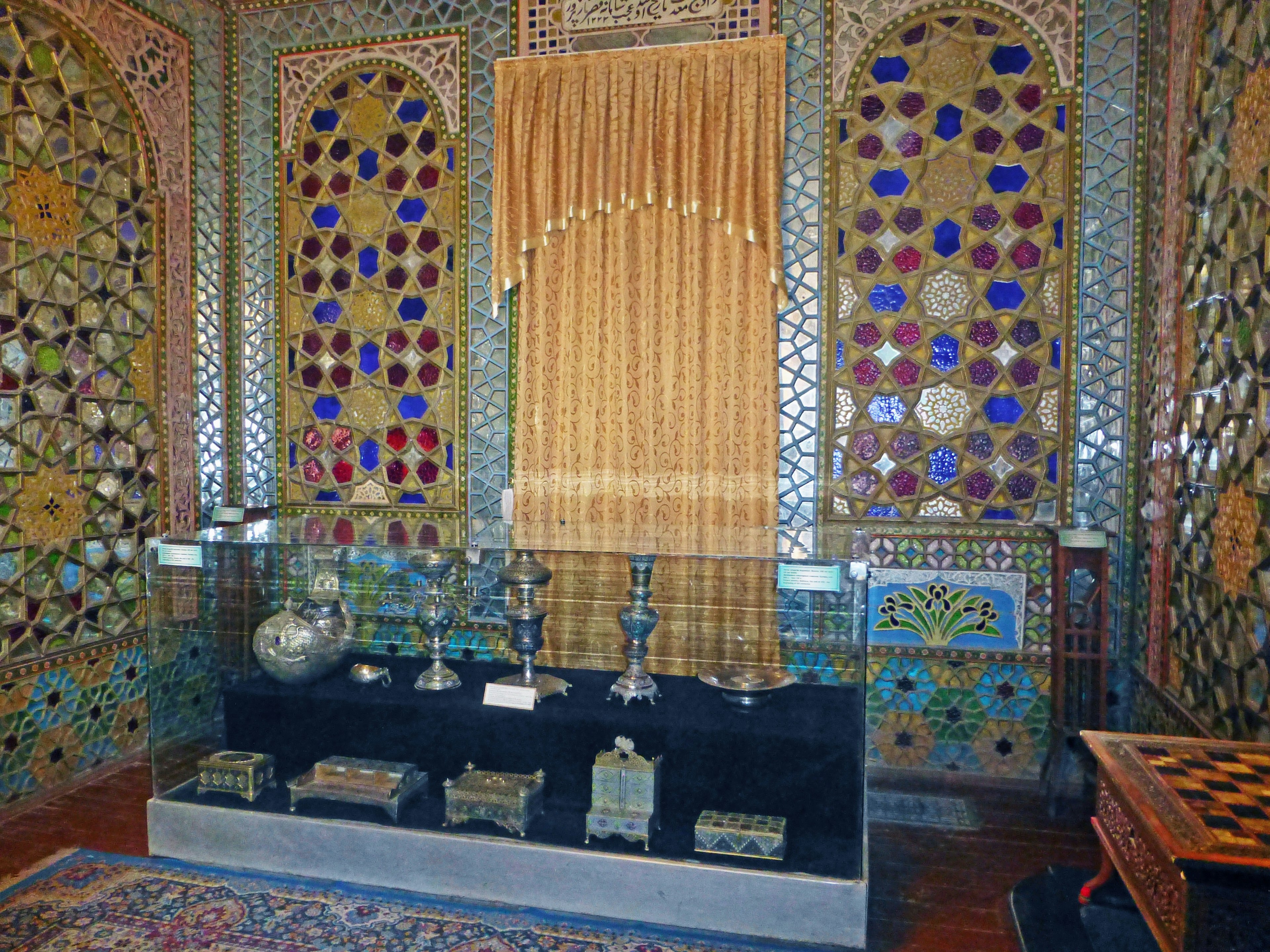 Chambre intérieure avec des fenêtres décoratives en verre coloré et des rideaux dorés