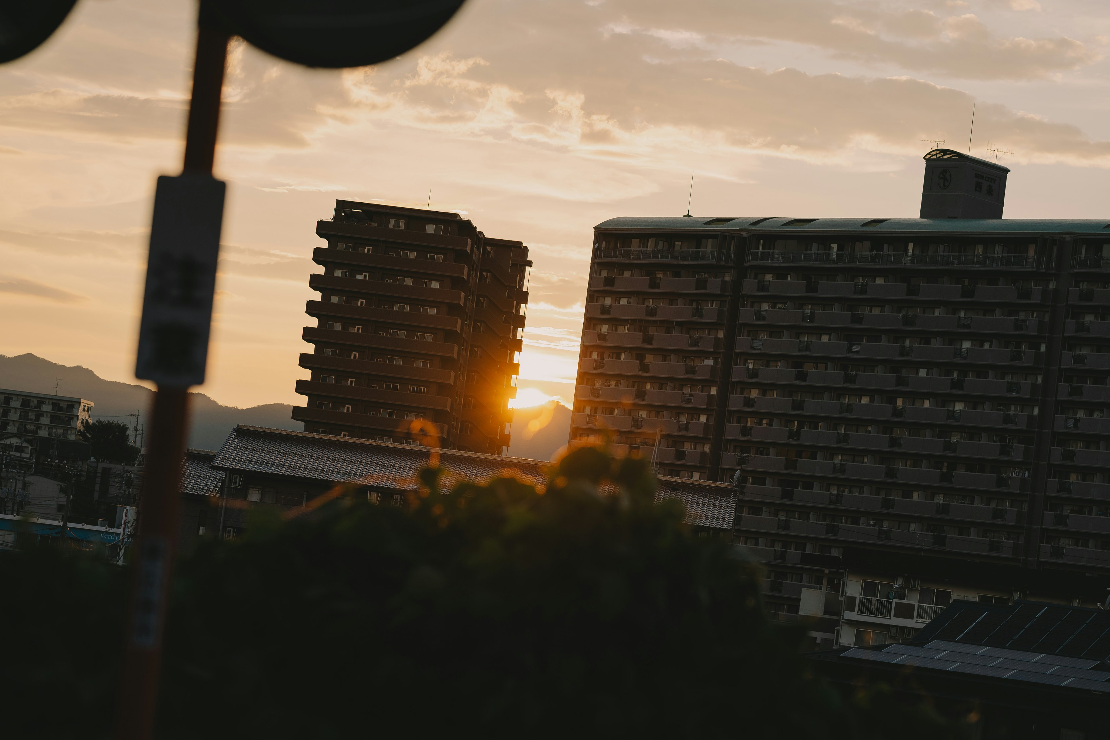 Paesaggio urbano con il sole che tramonta tra gli edifici