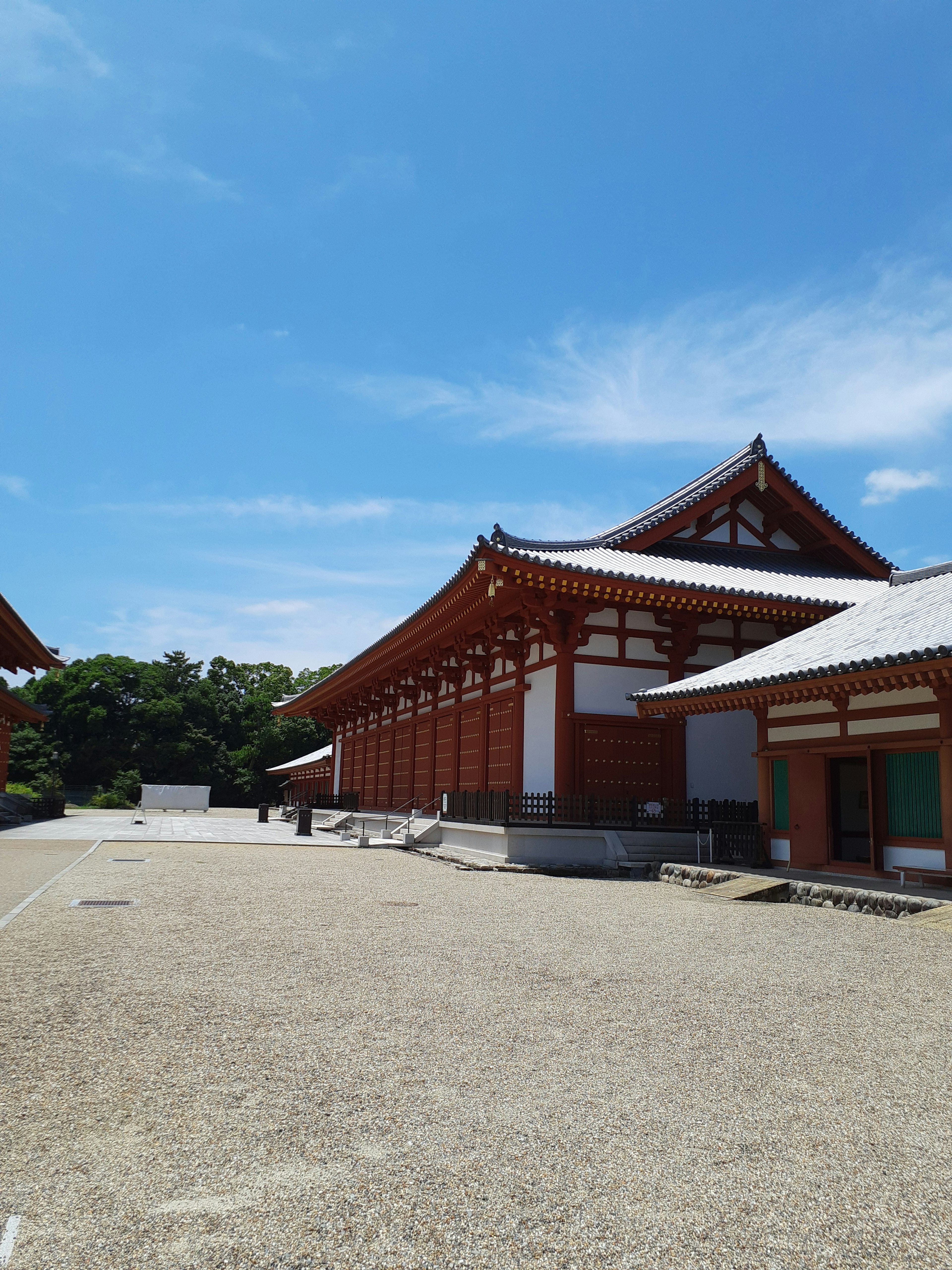 青空の下にある伝統的な日本の建物と広い庭