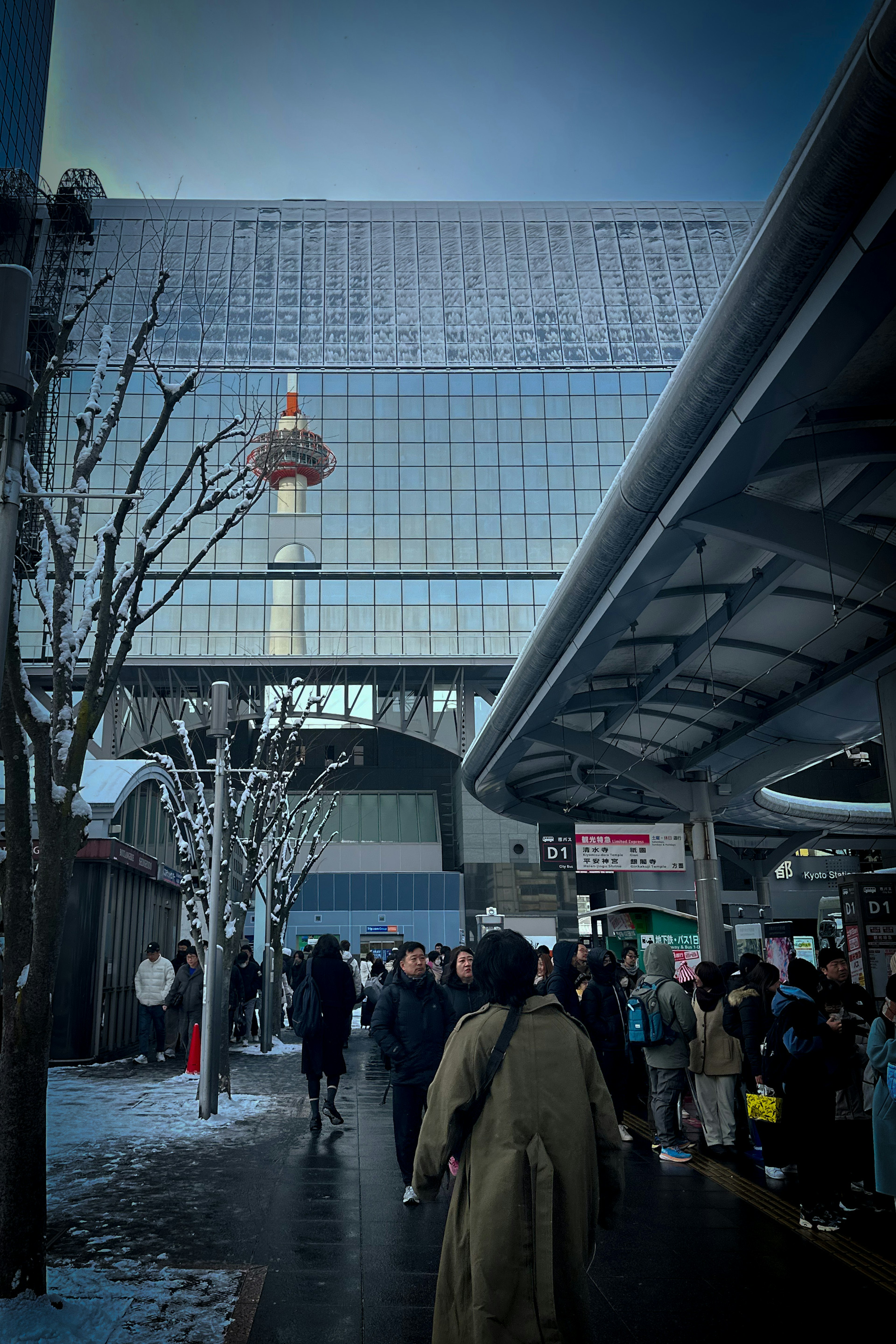 Belebte Straßenszene mit Menschen, die im Schnee gehen, in der Nähe eines hohen Gebäudes und eines Aussichtsturms