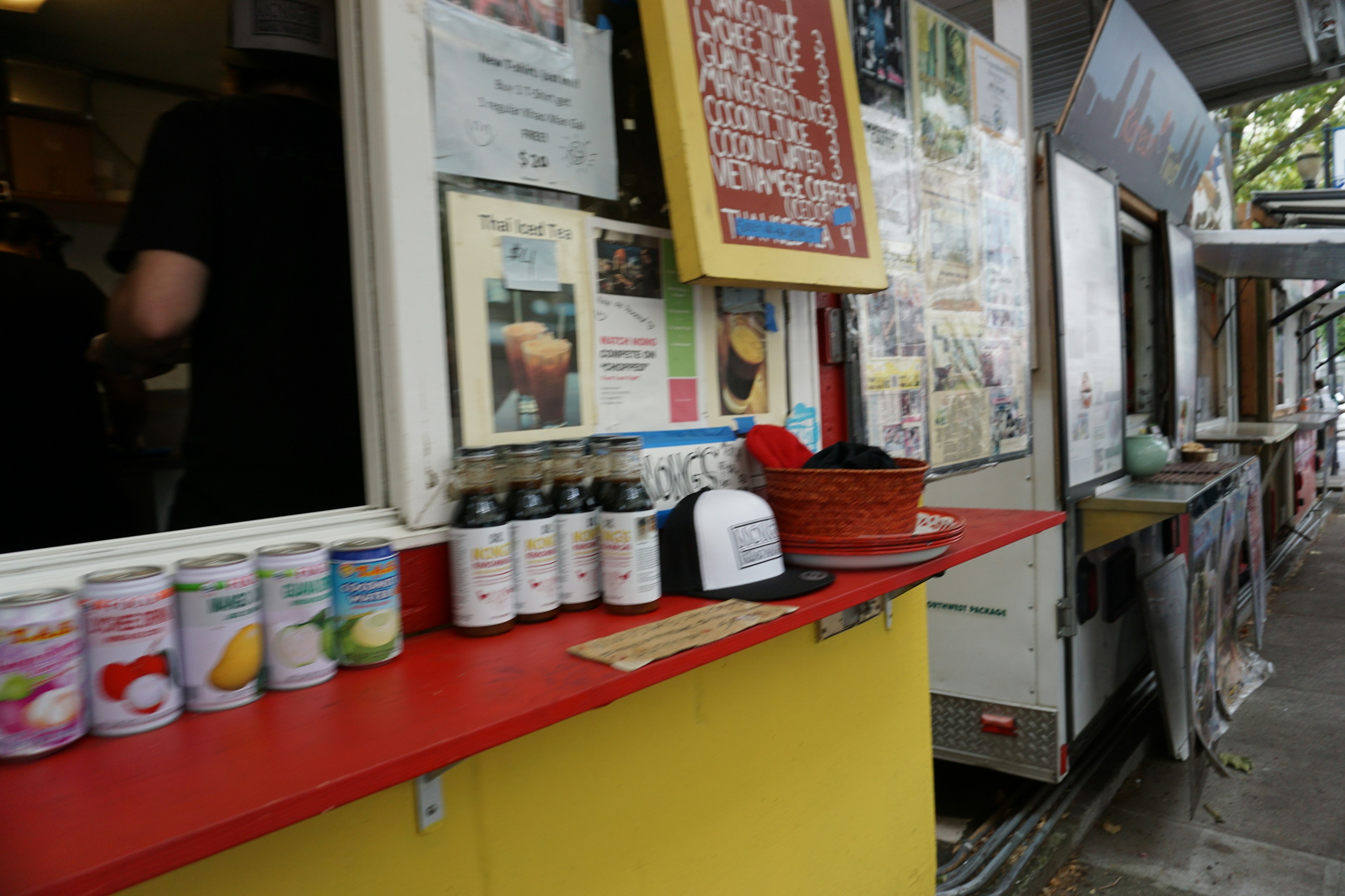 Colorful food stall counter with cans of drinks displayed