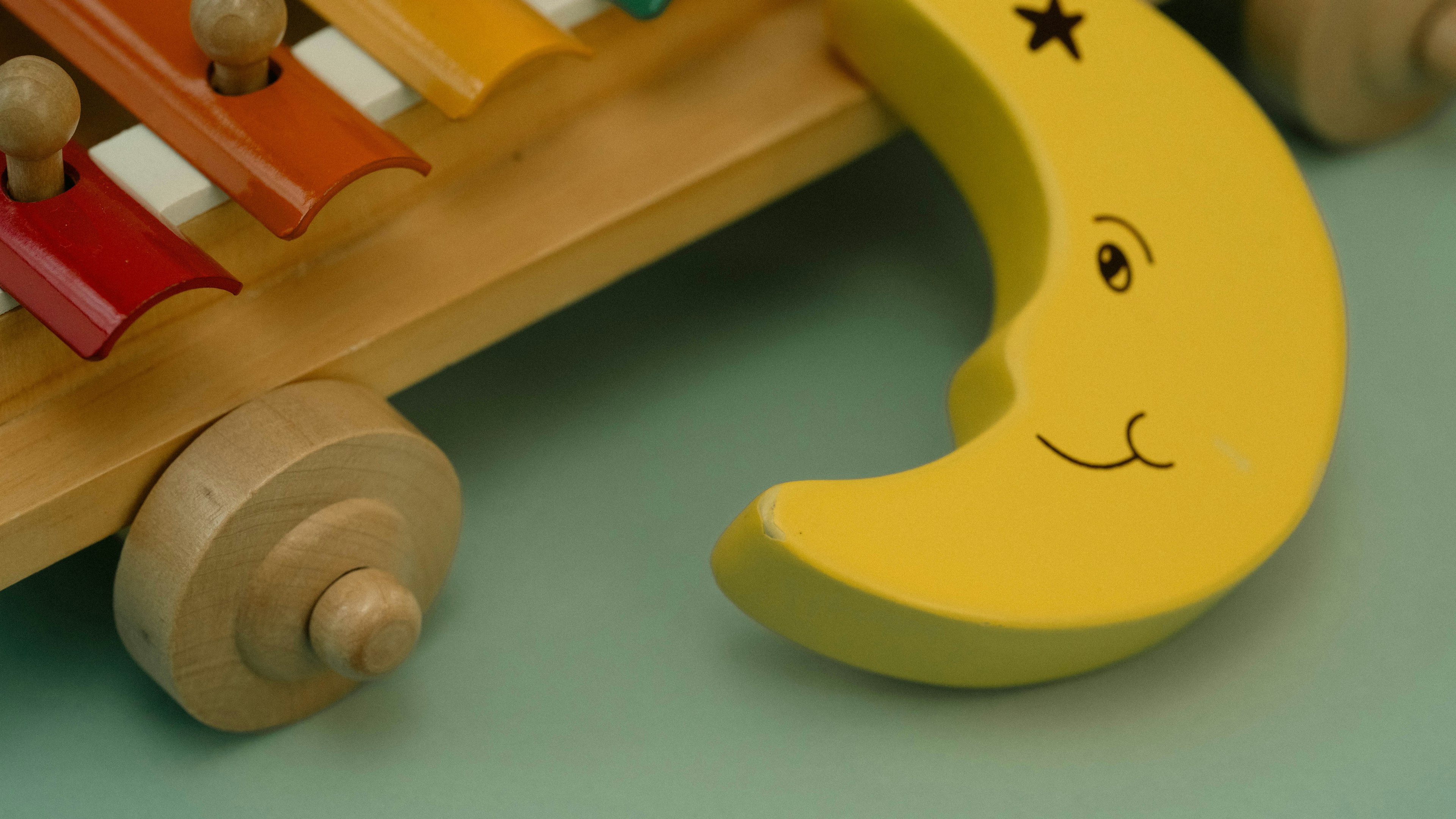 Smiling yellow moon-shaped piece on a wooden xylophone