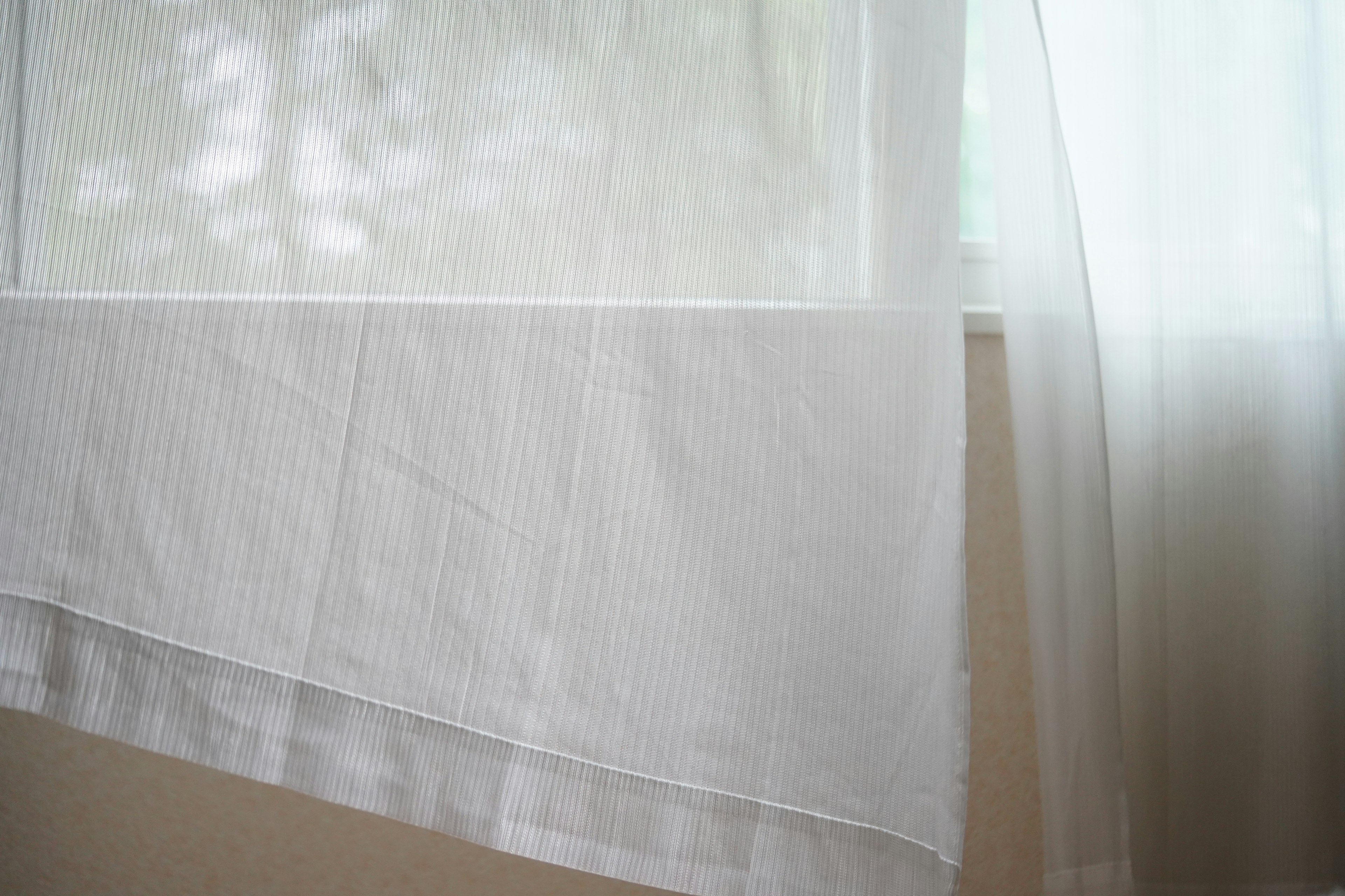 White curtain and sheer drape hanging at a window