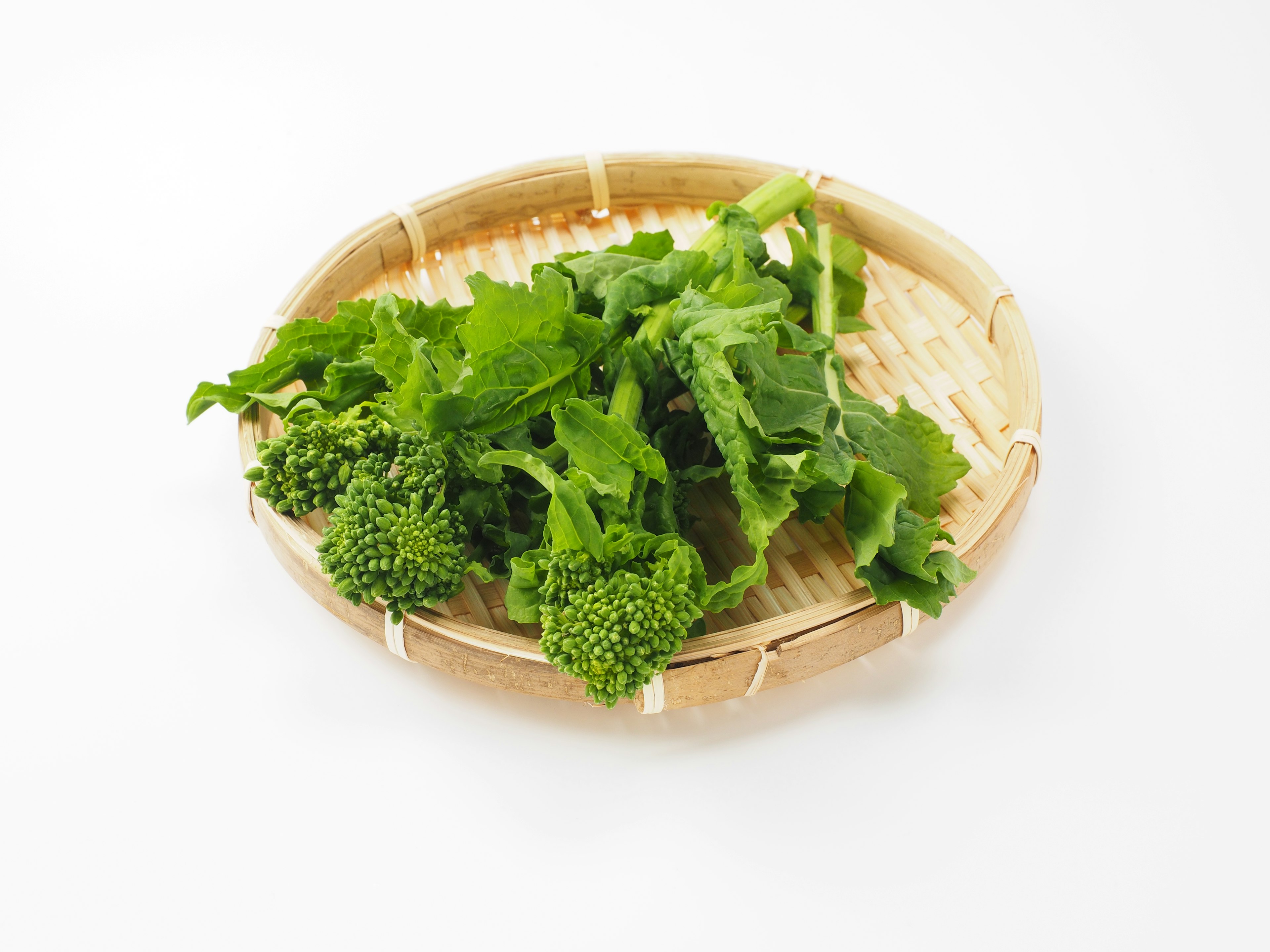 Fresh greens and broccoli on a bamboo plate