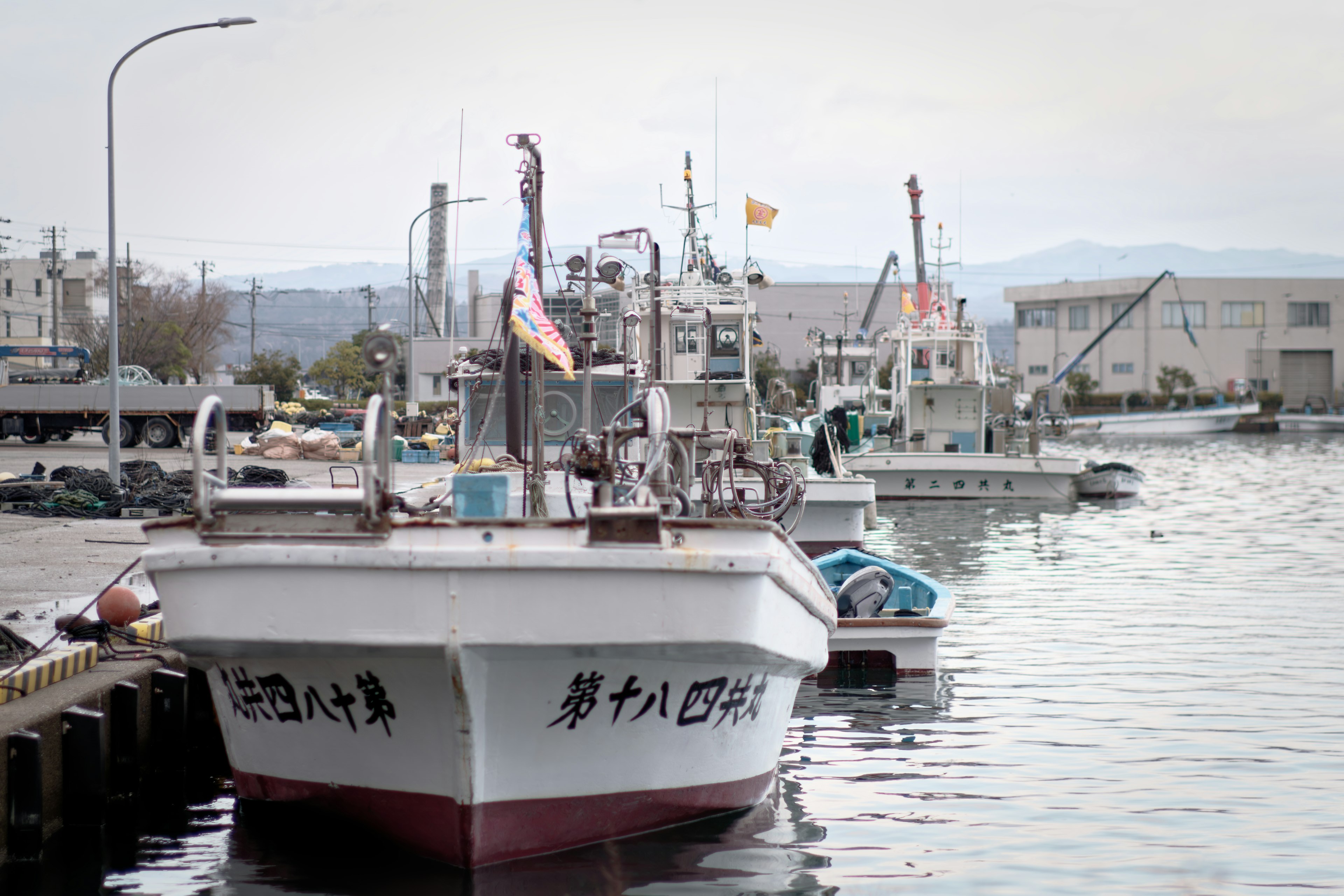 เรือประมงจอดอยู่ที่ท่าเรือพร้อมกับอาคารรอบๆ