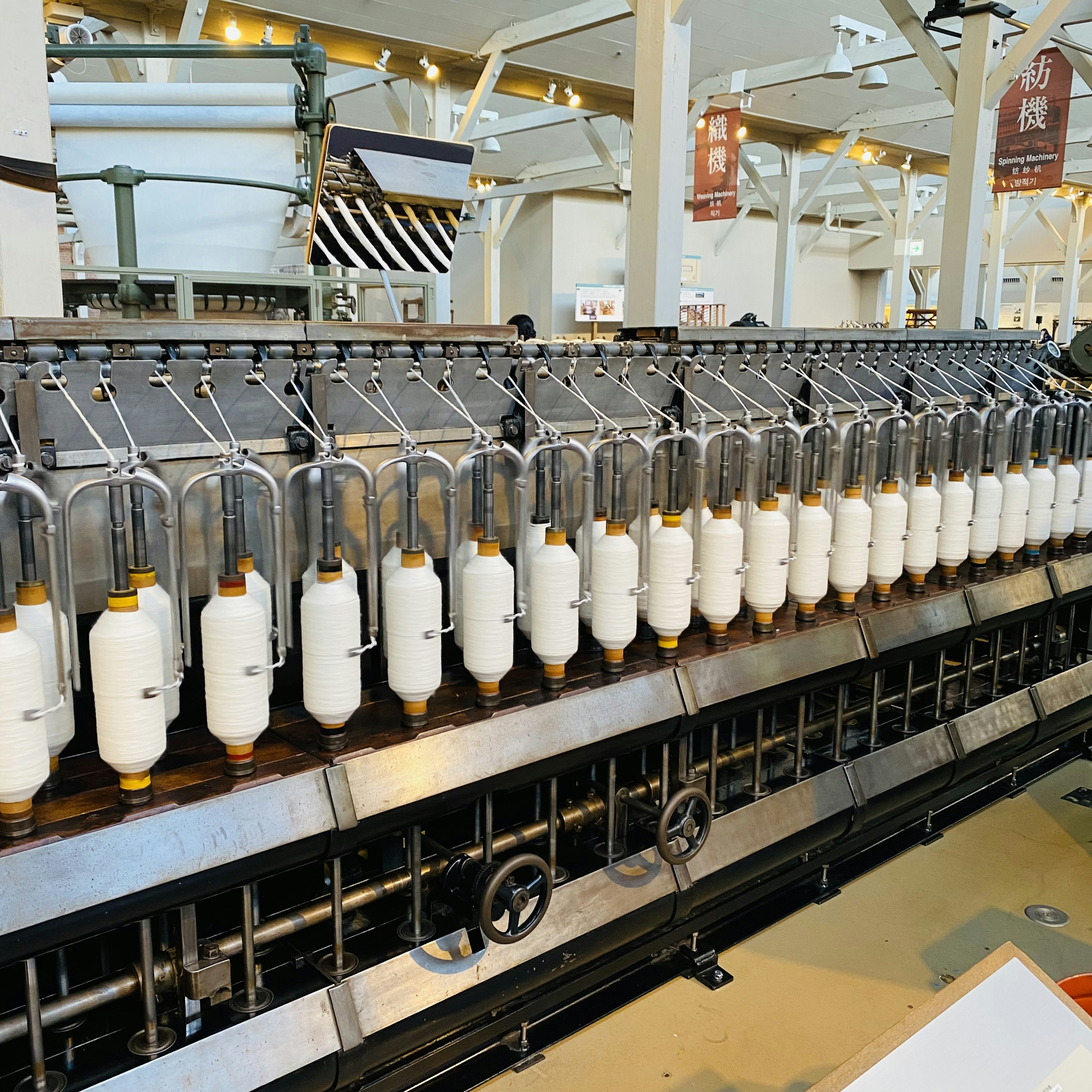 Industrial machine displaying white bottles and metal pipes