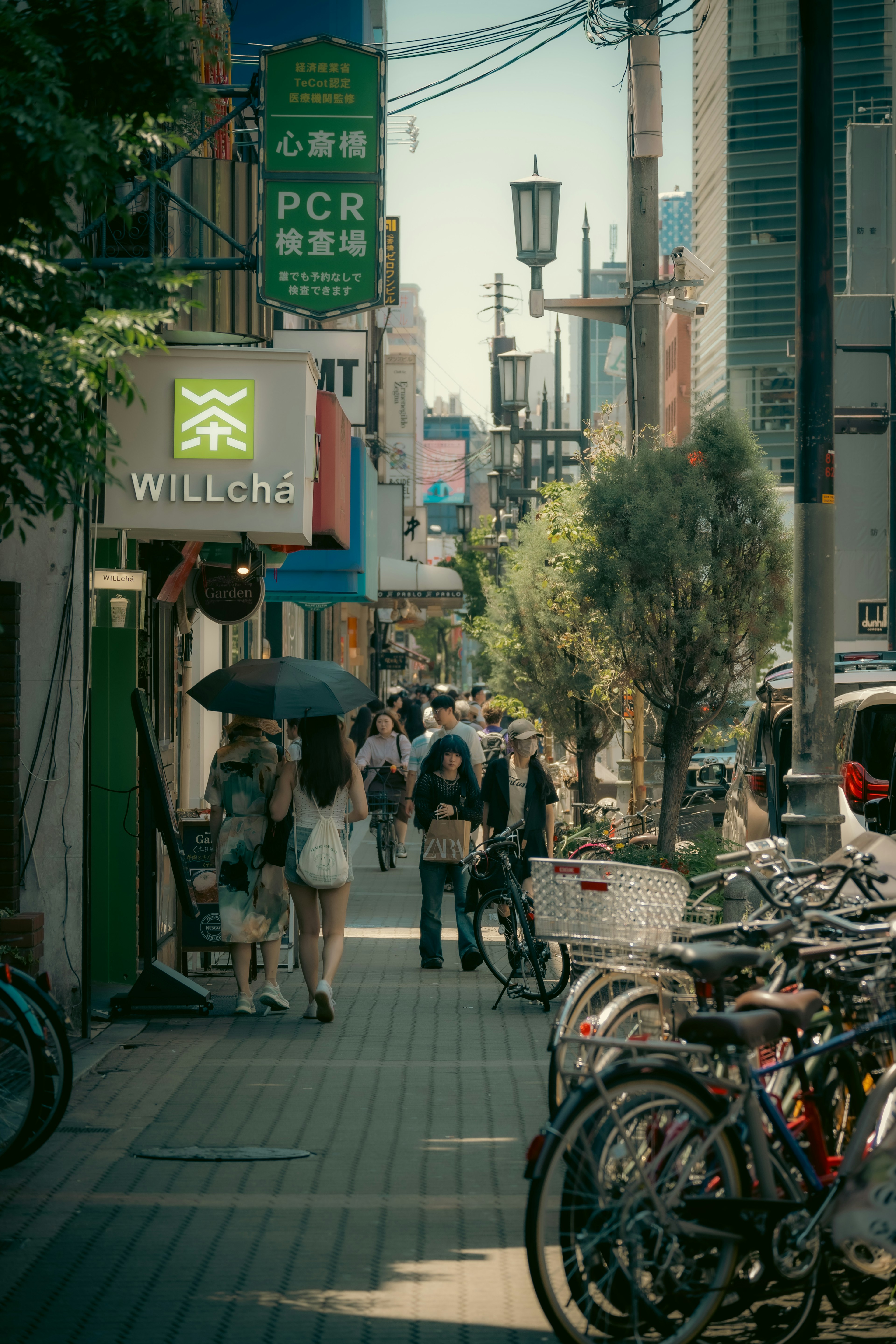 賑やかな街並みで人々が歩き、バイクが並ぶ風景