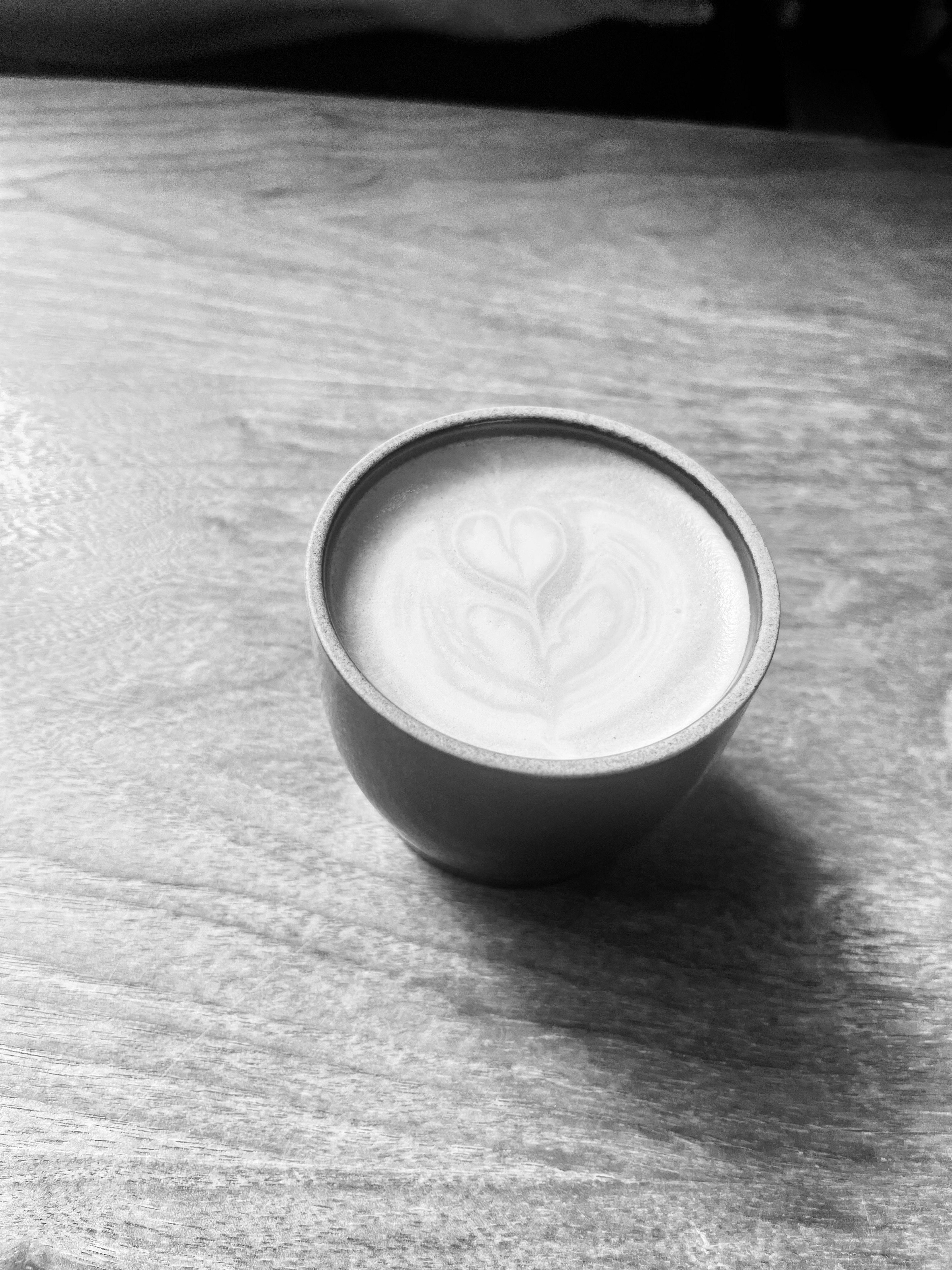 A cup of latte art on a wooden table