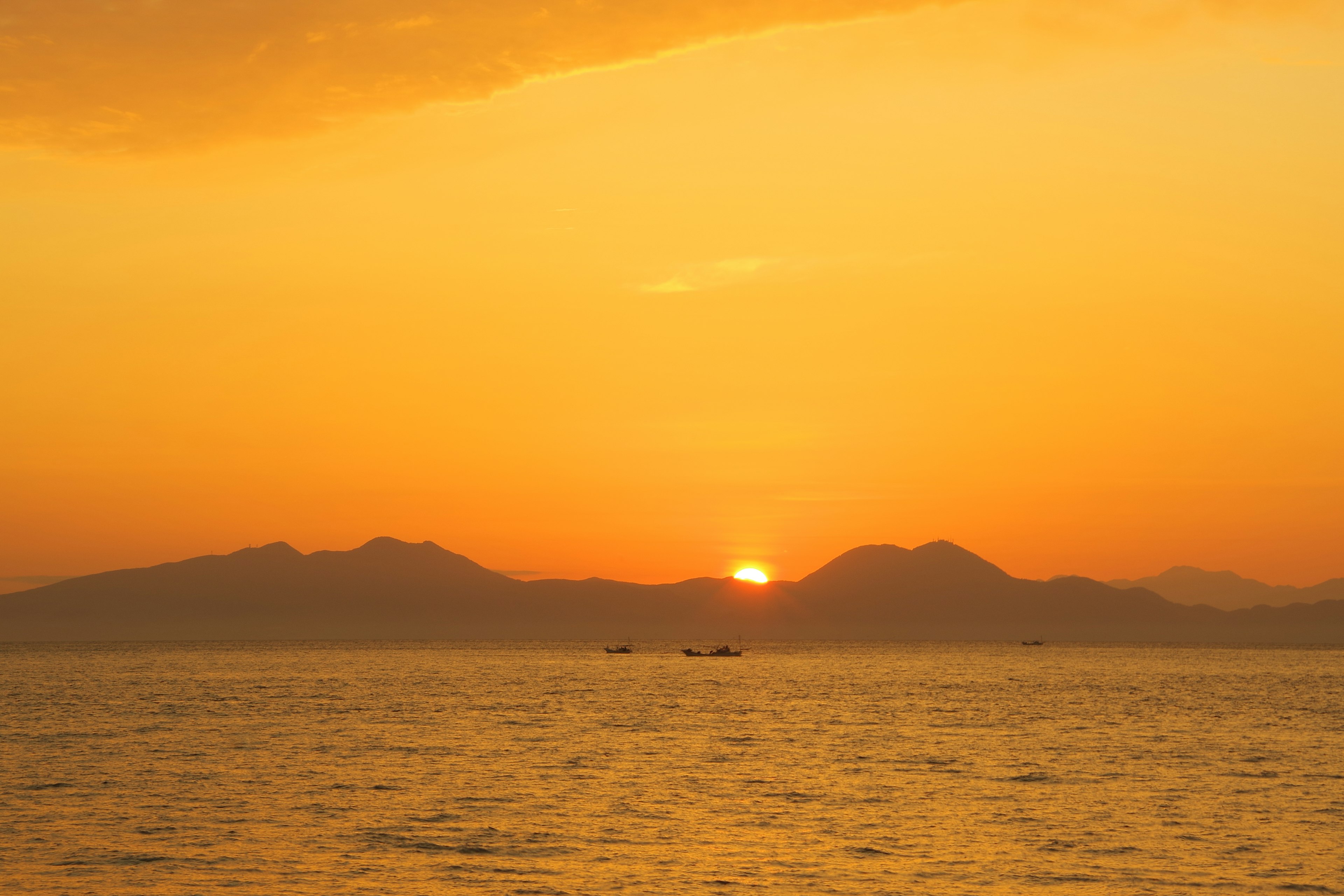 Beautiful orange sunset over mountains and calm sea