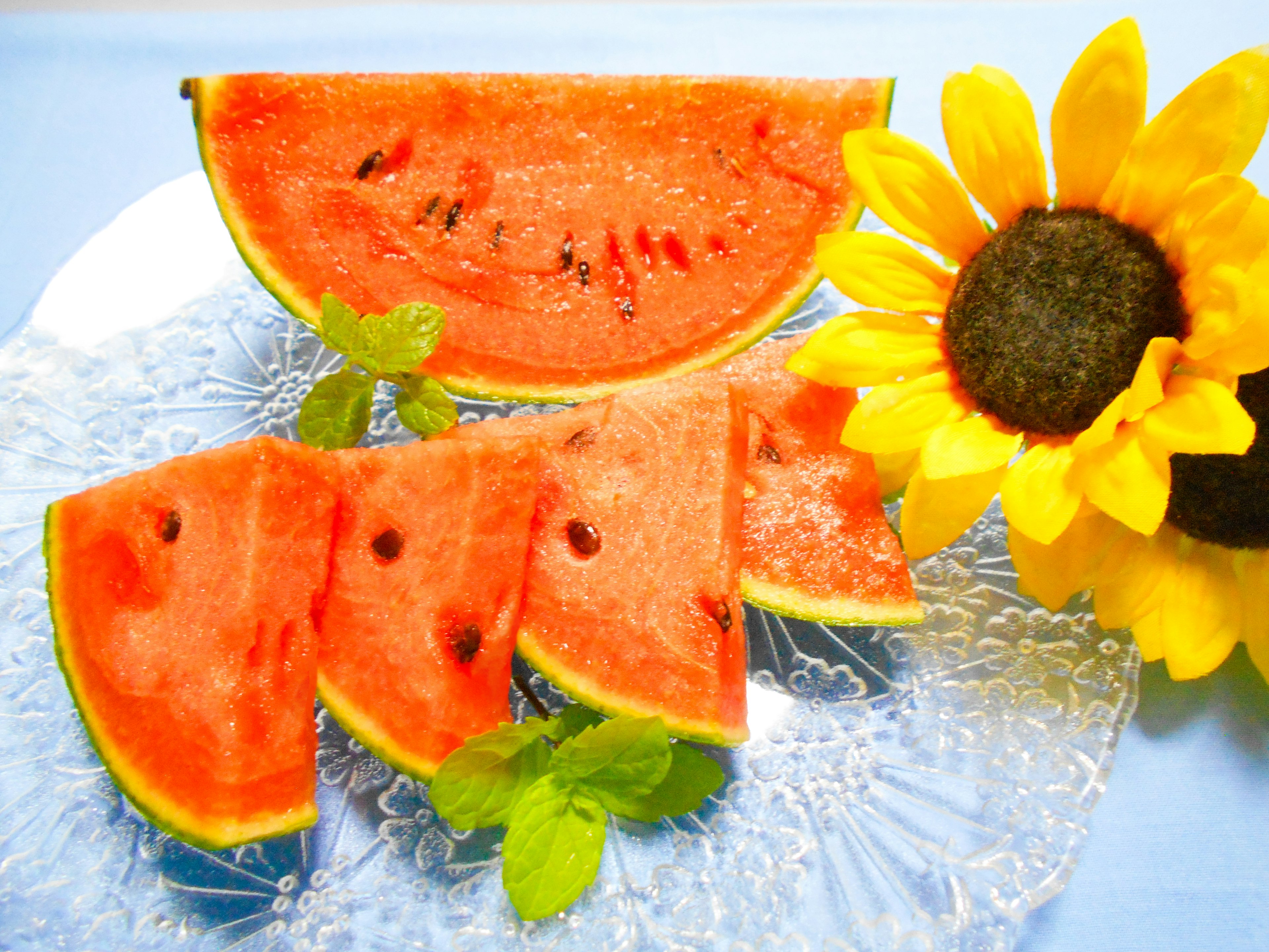 Rebanadas de sandía dispuestas con un girasol en un plato decorativo