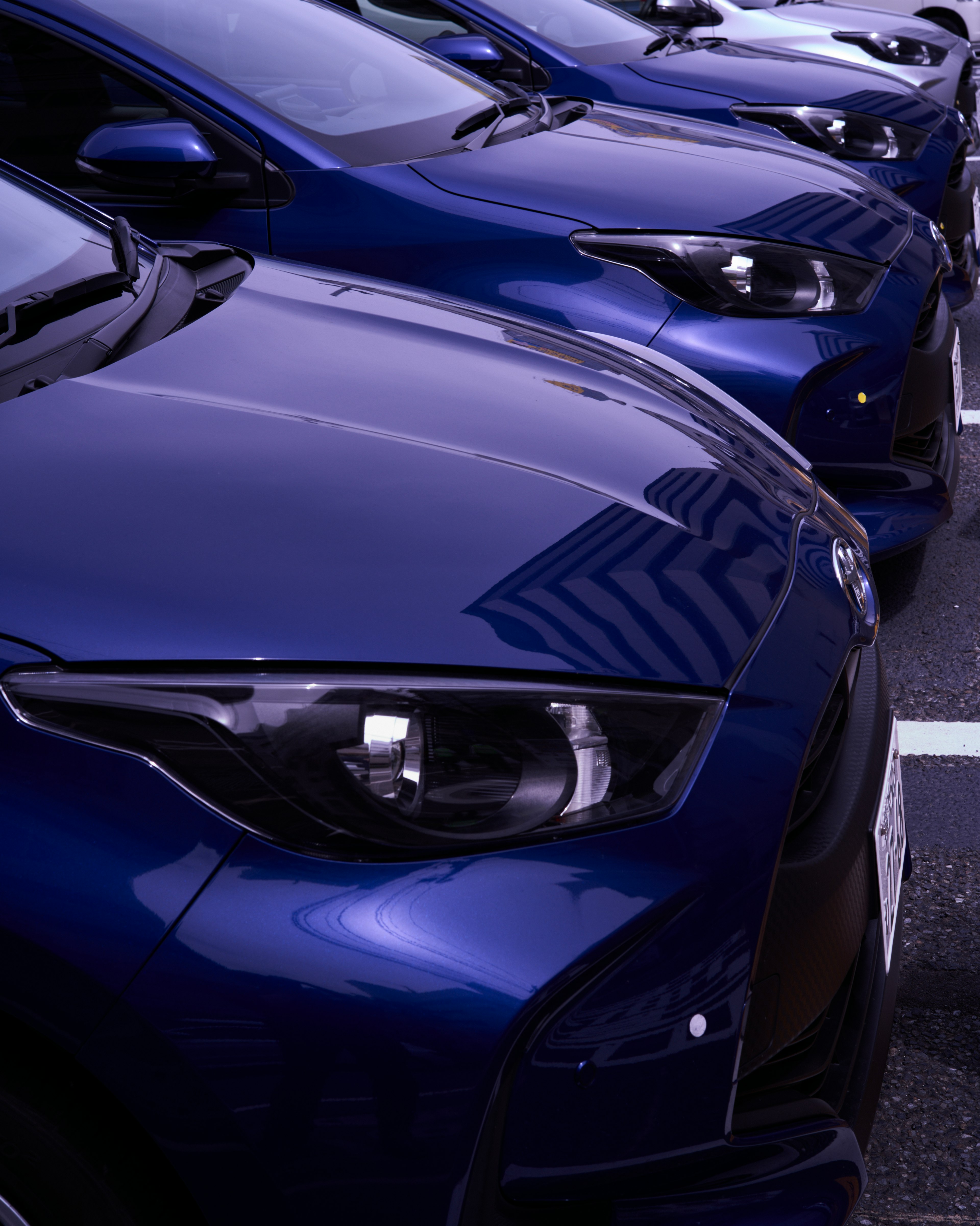 Row of blue cars parked in a lot