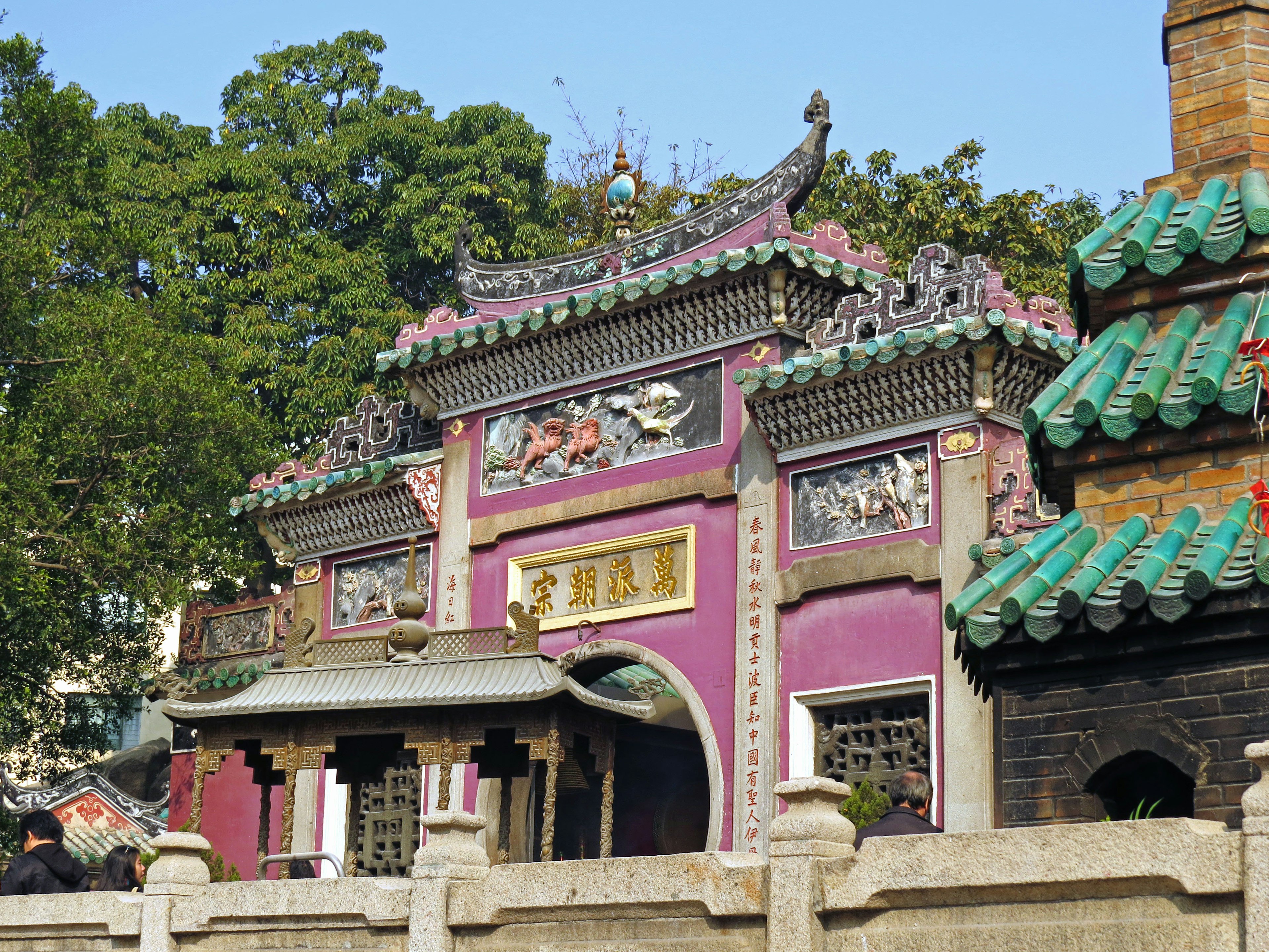 Exterior de un templo chino tradicional con paredes moradas y techo verde