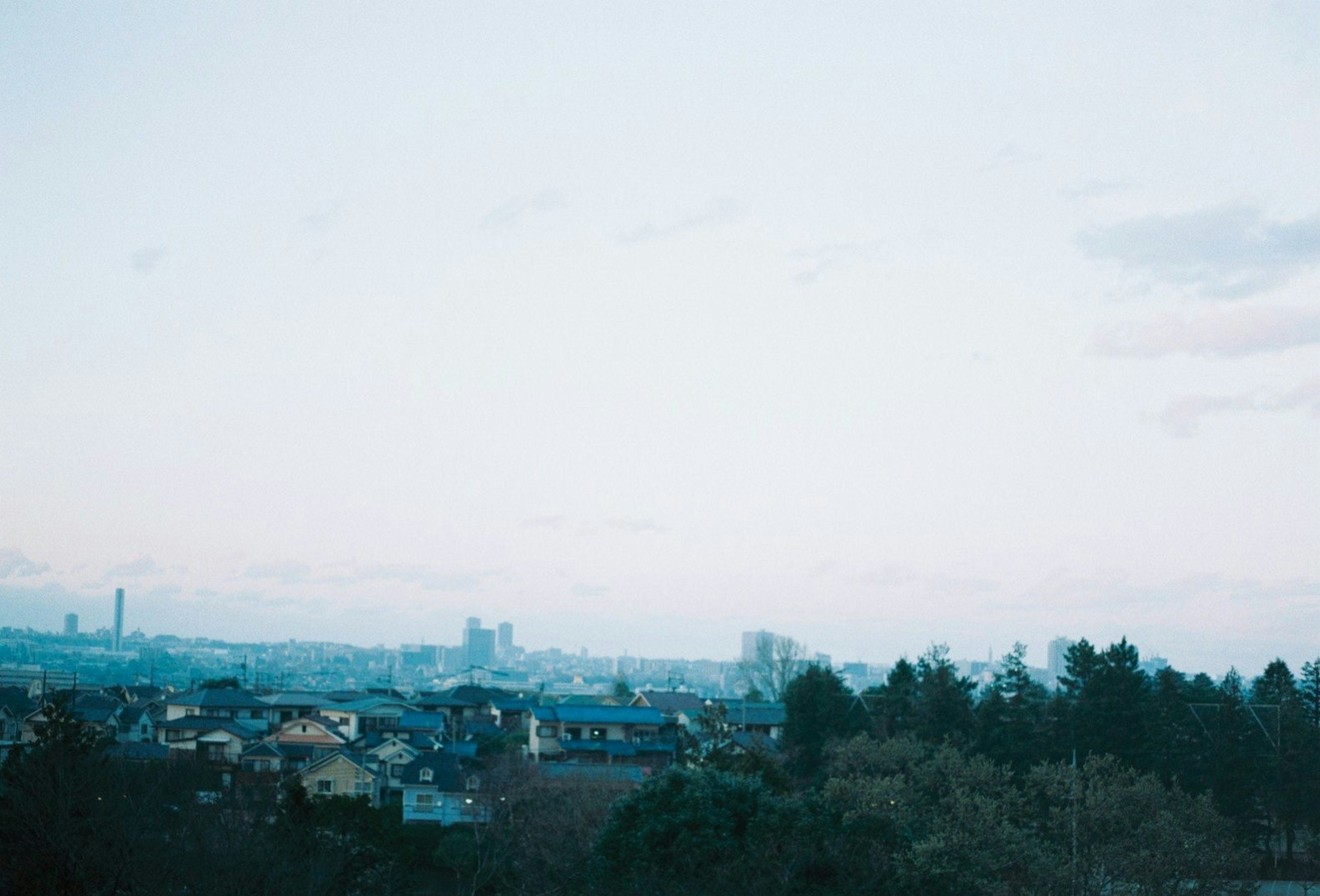 Paysage urbain avec ciel bleu et nuages présentant des arbres verts