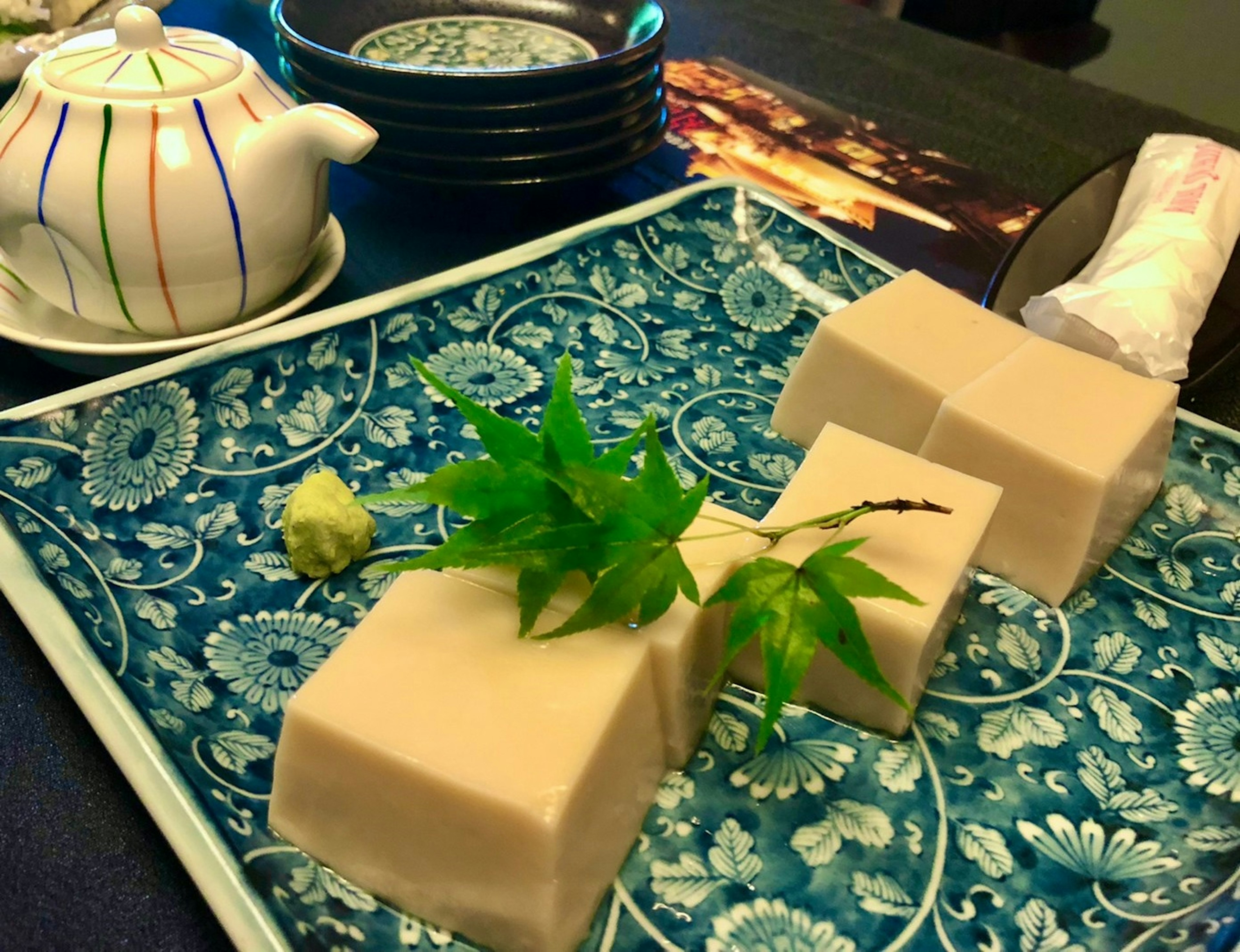 Hermoso plato azul con bloques de tofu y decoración de hojas verdes