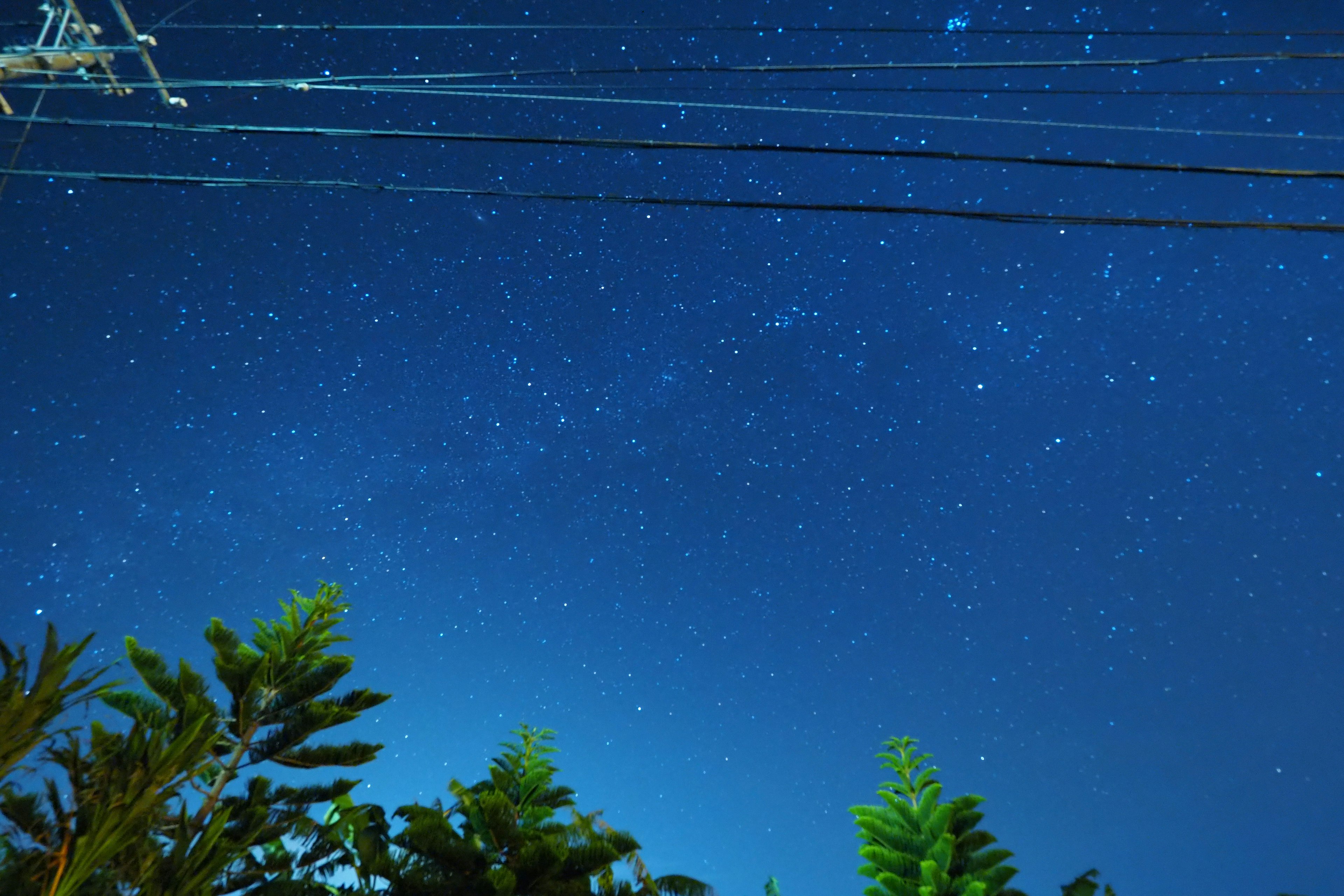 Ciel étoilé nocturne avec des lignes électriques visibles