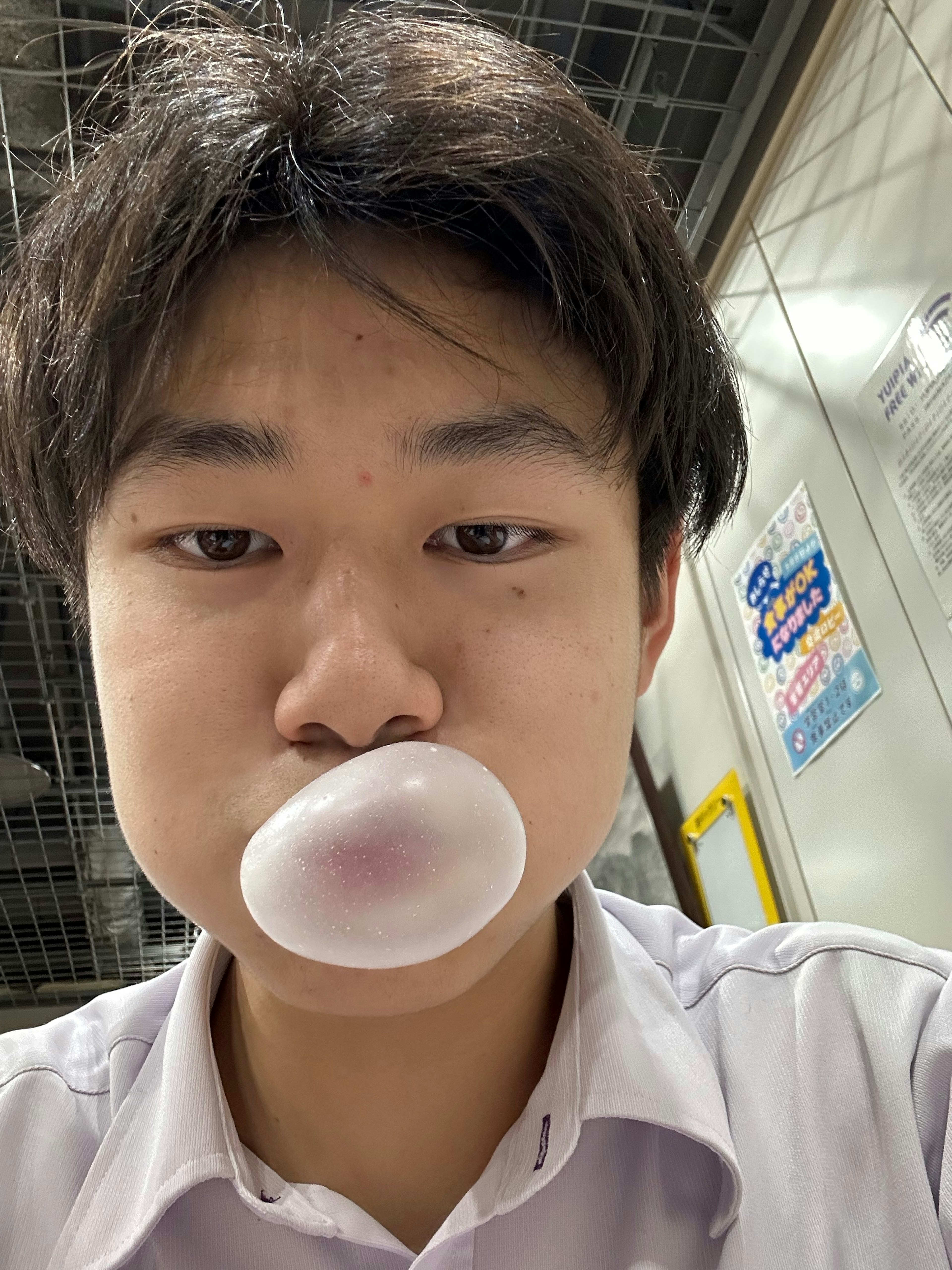 Young man blowing a large bubble with gum