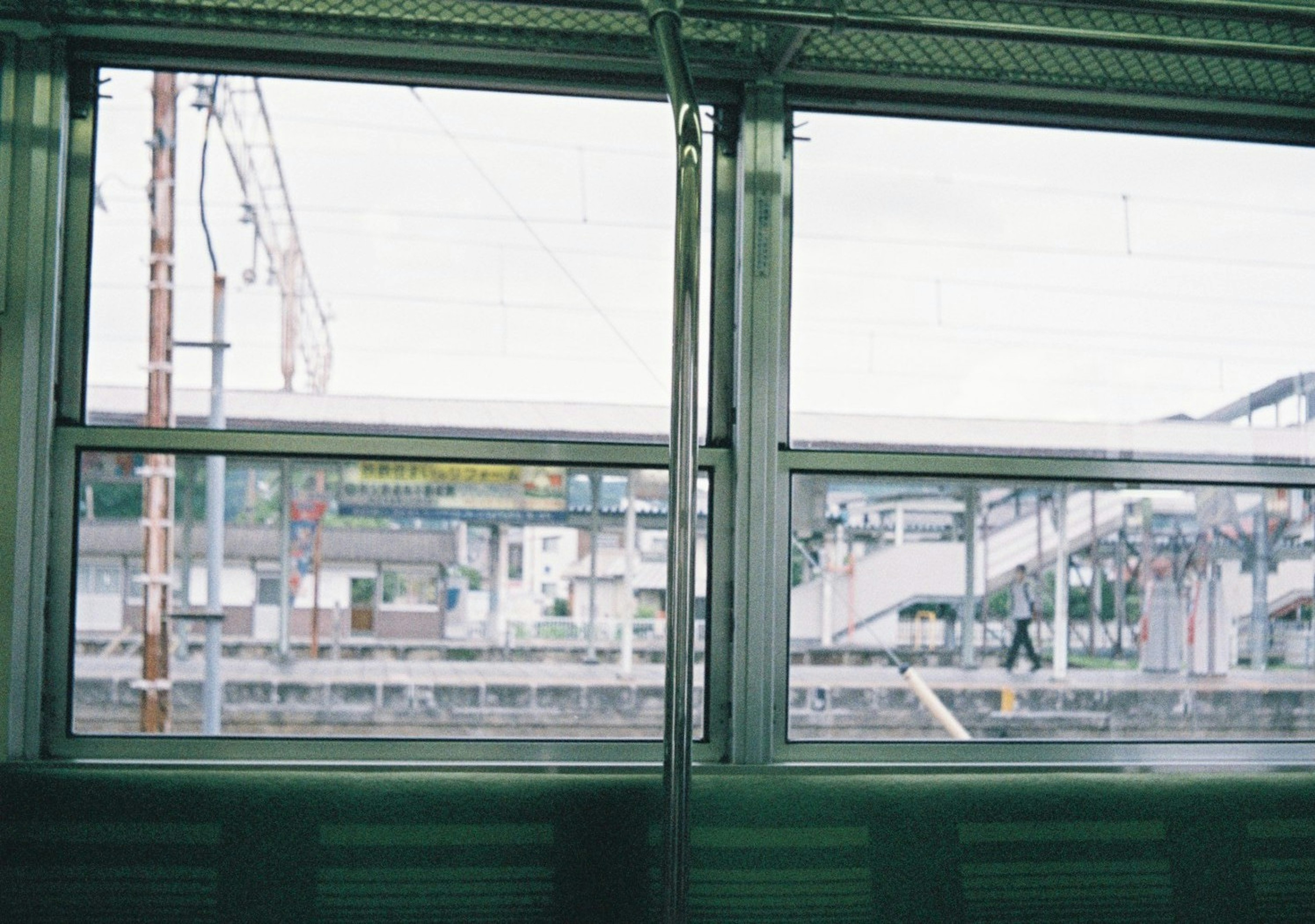 車両の窓からの風景 鉄道駅の線路と建物が見える