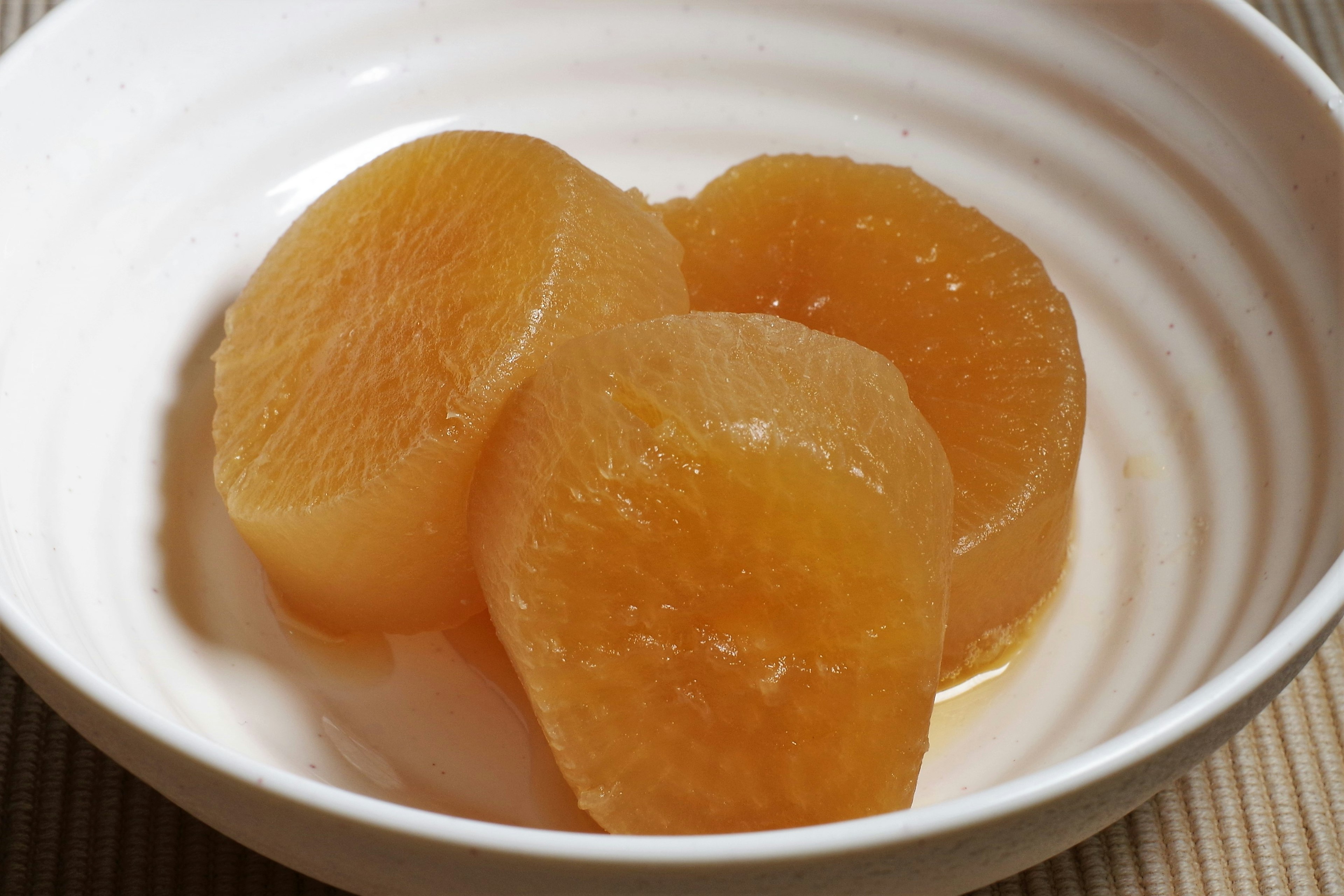 Three slices of sweet daikon in a white bowl