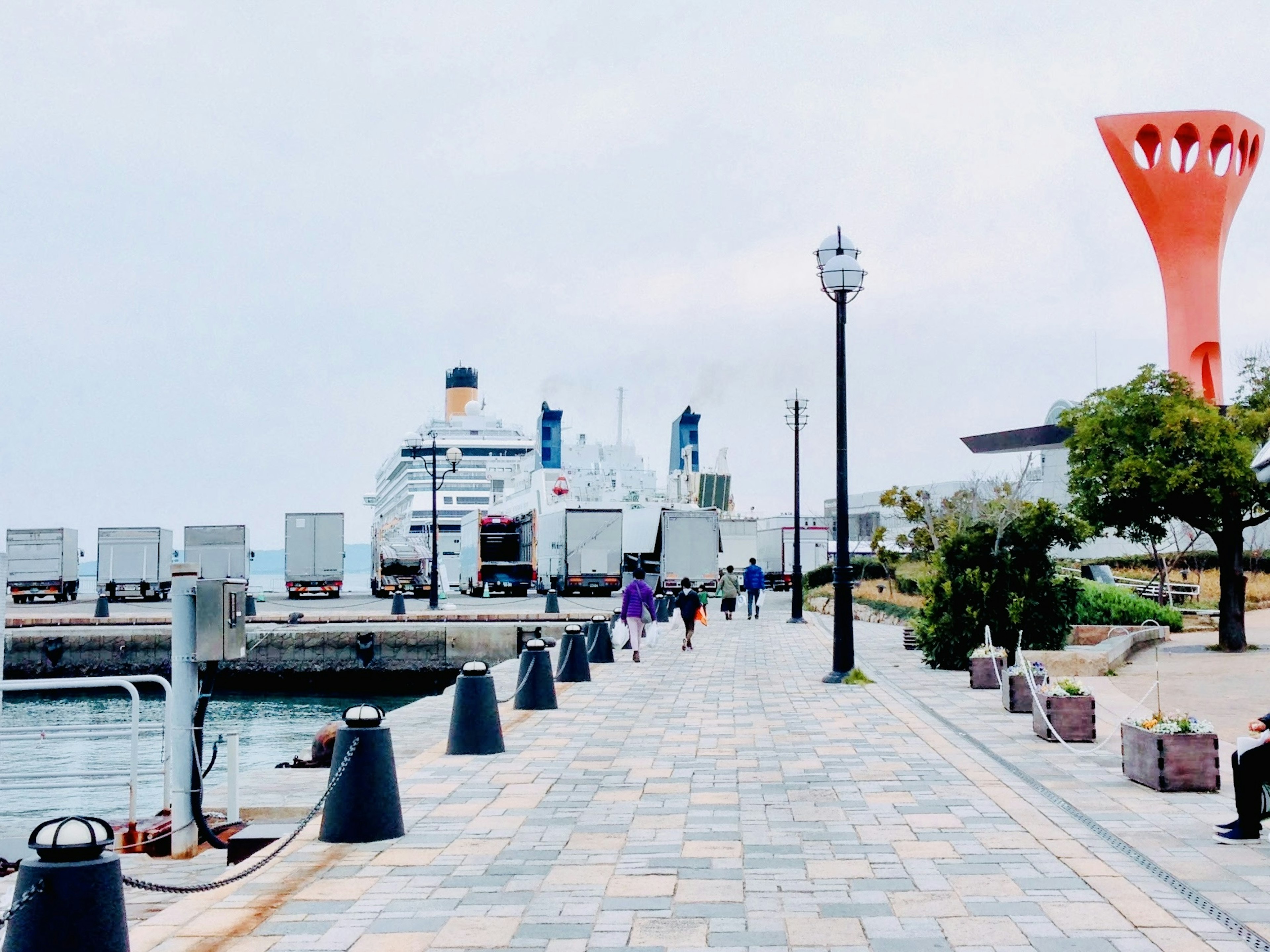 Malerscher Uferweg mit einem Kreuzfahrtschiff und einem orangefarbenen Turm