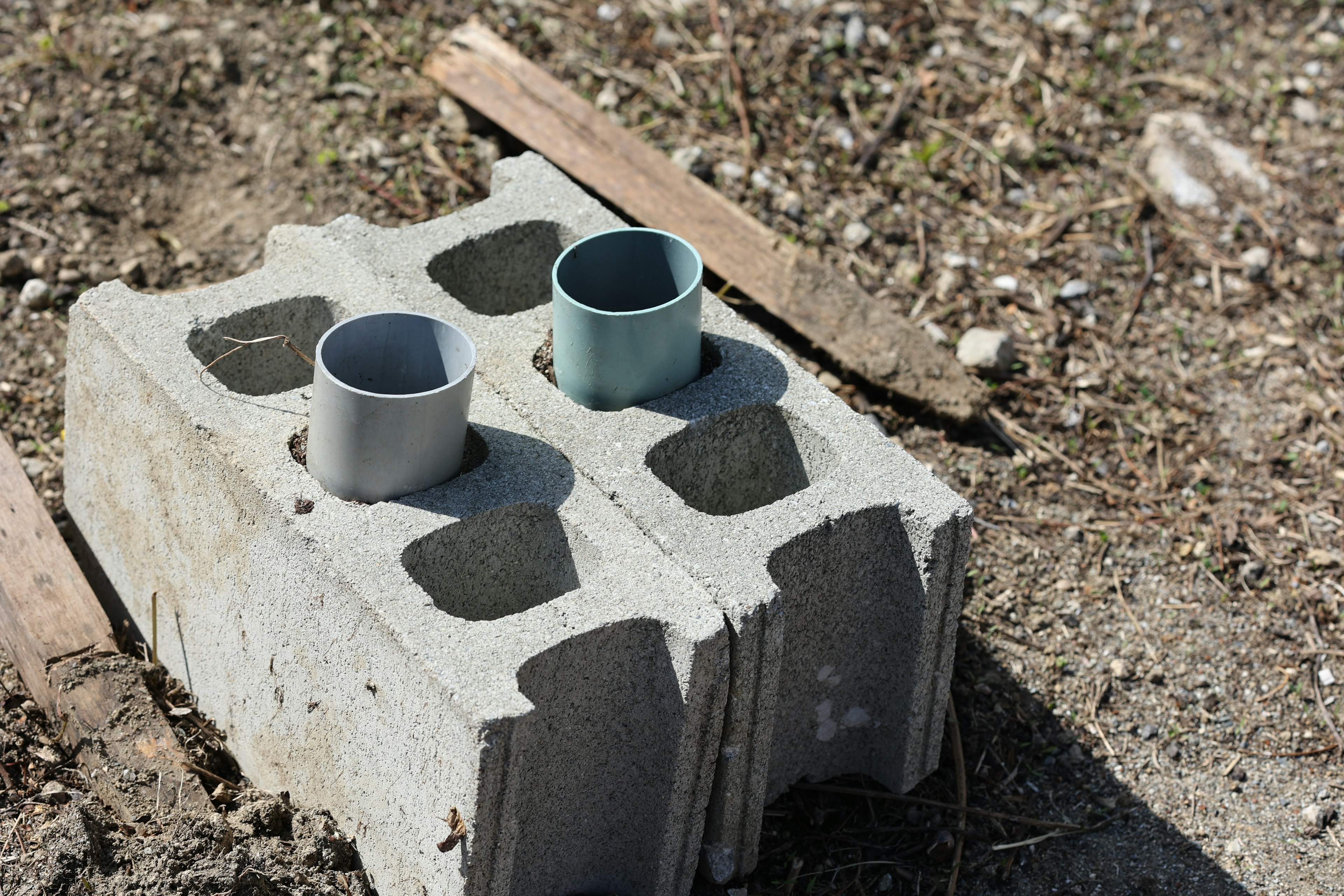 Dos tubos colocados sobre un bloque de concreto en el suelo