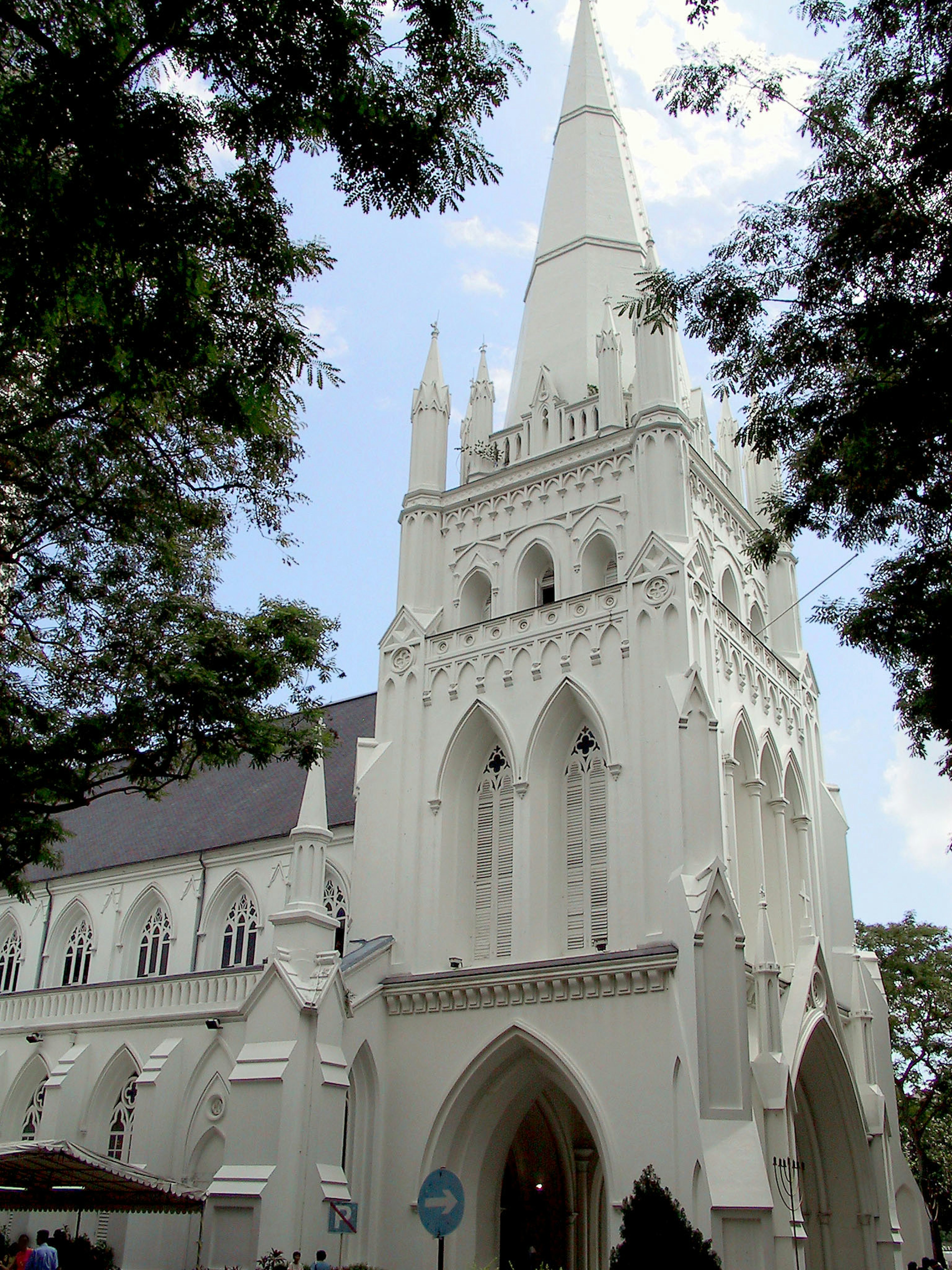 Église de style gothique blanc avec une haute flèche et une entrée en arc