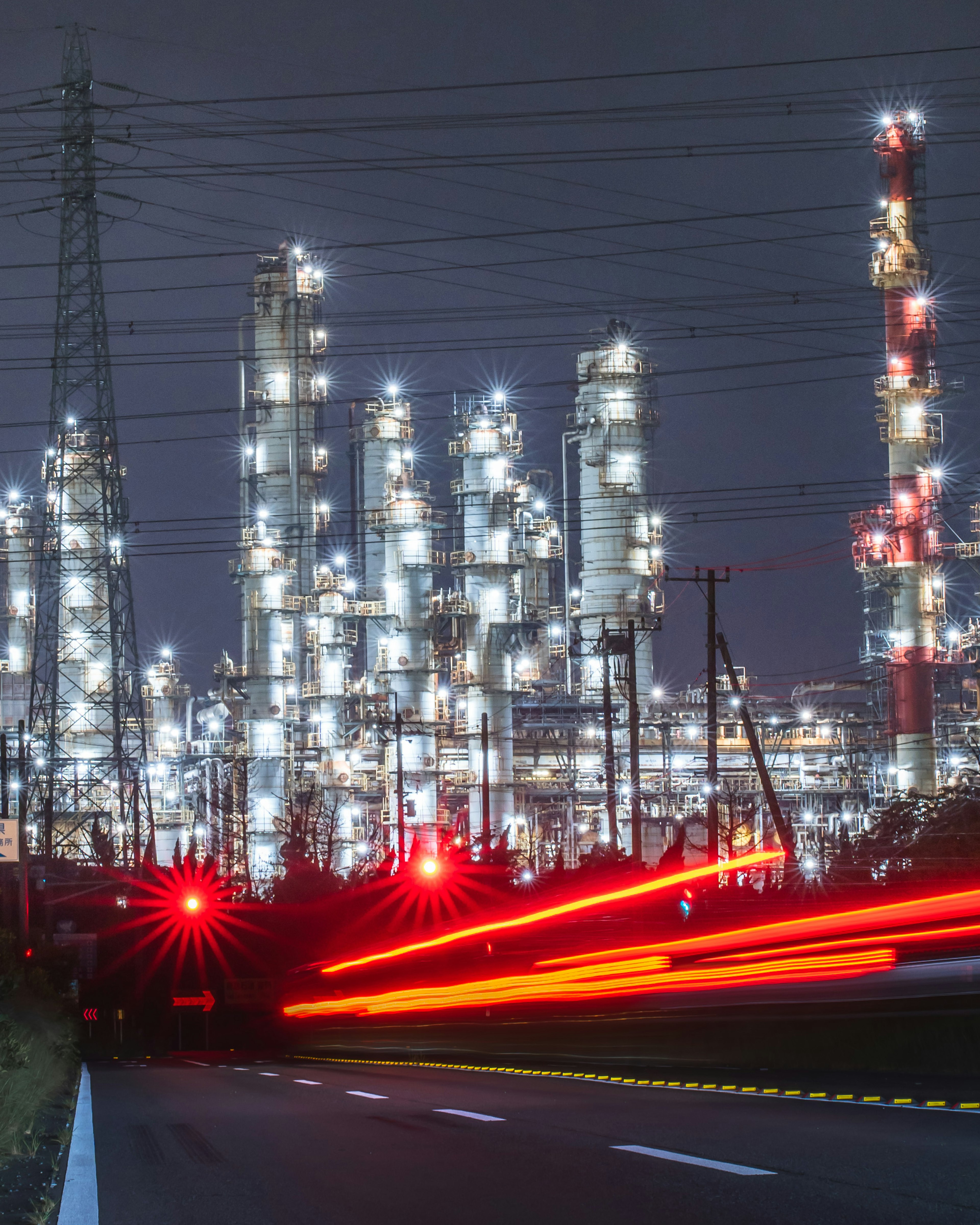 Vista notturna di una raffineria di petrolio illuminata in un'area industriale