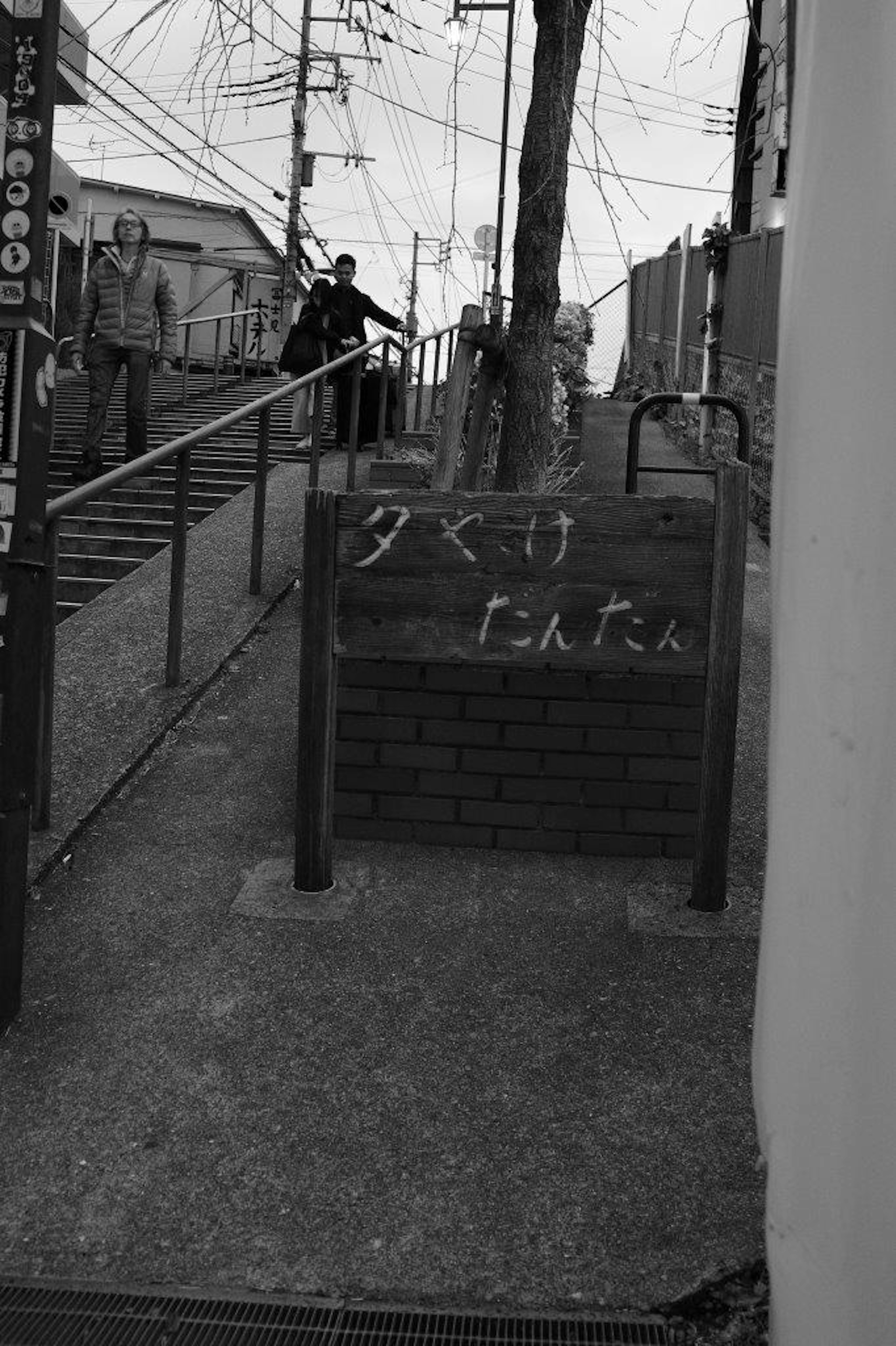 A blackboard on a slope with a handrail showing handwritten text