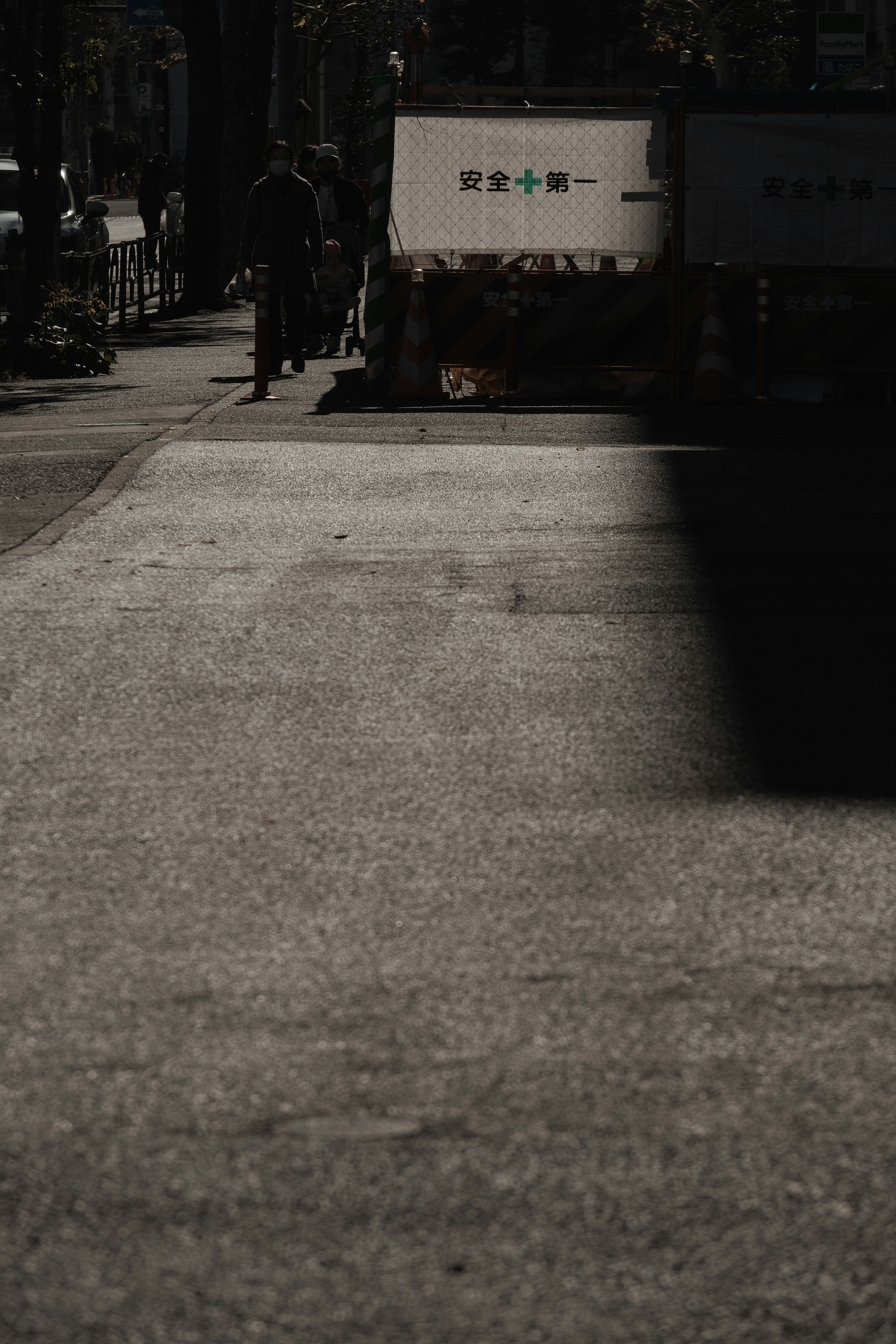 Person walking on a dark street with trucks in the background